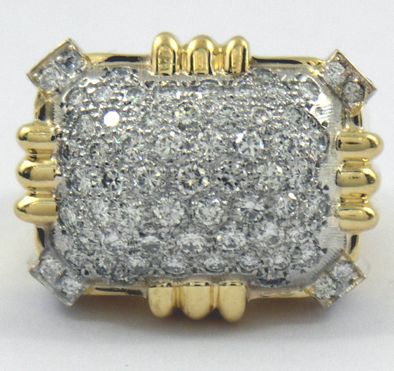 One 18K yellow gold ring measuring 3/4 of an inch long and 1 inch wide. This ring is set with G color VS1 clarity round brilliant cut diamonds, weighing a total of approximately 2.25ct. The contoured motifs on the north, south, east, and west of the