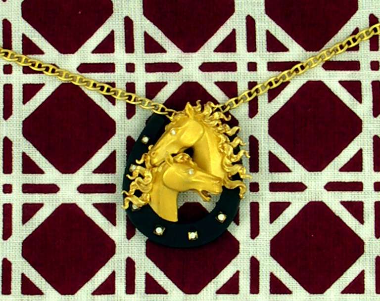 From the renowned firm of Carrera y Carrera comes this handsomely made, 18K equine pendant. The pendant itself measures 1 inch wide and 1 1/4 inches long, and the chain from which it hangs measures 19 inches.The anchor link chain measures