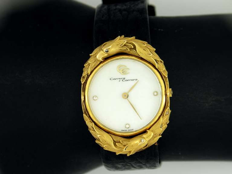 Carrera y Carrera lady's 18k yellow gold wristwatch, featuring an eagle design. The eye of each eagle is a beautifully set round brilliant cut diamond. The mother-of-pearl dial is set with diamonds at the 3, 6, and 9. The outside of the case