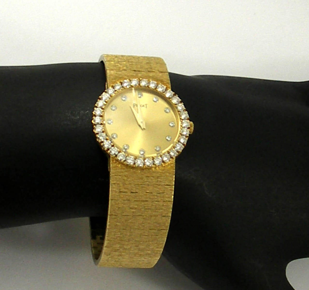 An 18K yellow gold Piaget wristwatch measuring 6 3/4 inches long, and set with 42 round brilliant cut diamonds weighing 1.25ct total approximate weight. Watch is in excellent condition.