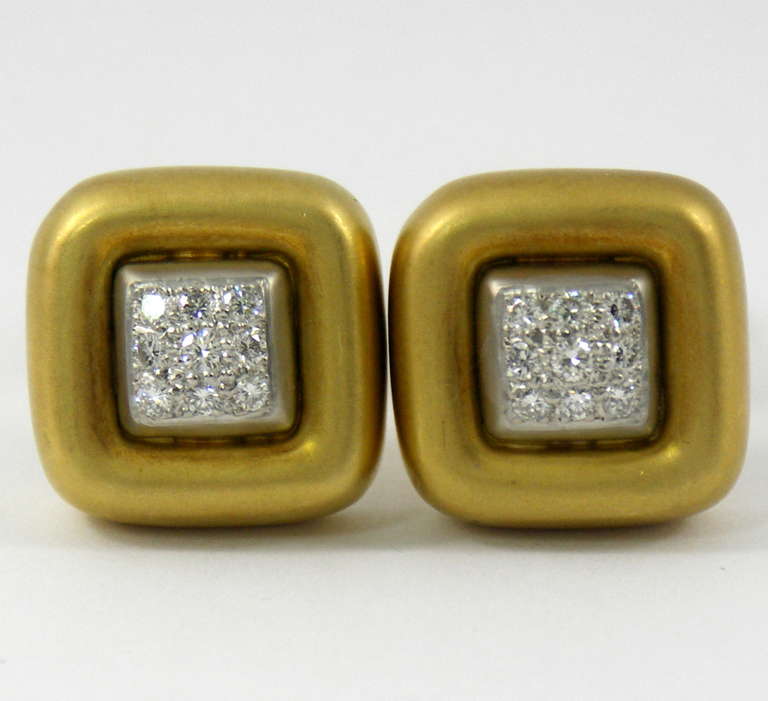 A pair of 18K yellow and white gold beautifully pave' set with approximately 0.75ct of round brilliant cut diamonds. Measuring 3/4 of an inch wide, they feature a beautifully satin finished yellow gold border roughly 1/8 of an inch wide. Inside the