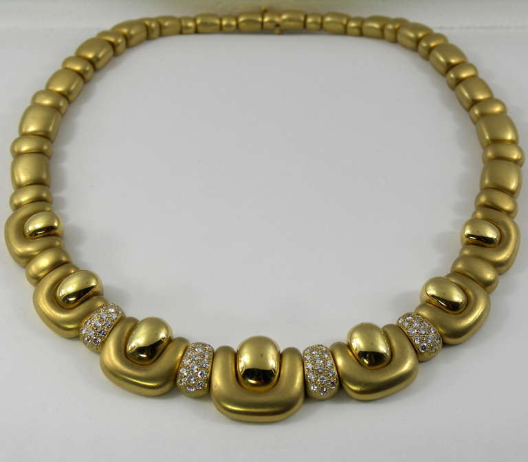 Eine Halskette aus 18 Karat Gelbgold von Marlene Stowe mit abgerundeten Gliedern, die zu einem Mittelteil mit sieben zentralen Gliedern führen, und vier mit Pflastersteinen besetzten Stationen. Jedes zentrale Glied besteht aus einer