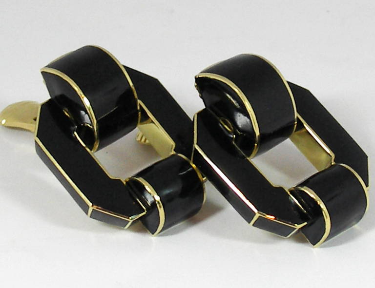 A pair of 18K yellow gold David Webb earrings featuring a geometric design, and black enamel. Central to the design is an octagon, which is then elongated visually, by the use of a 5/8 of an inch, hinged arc at the top, and an affixed arc measuring
