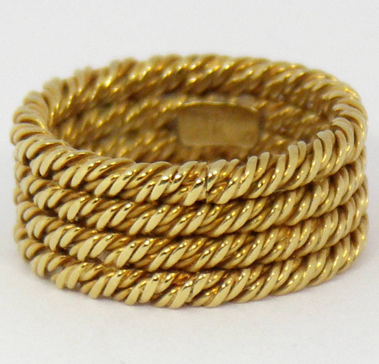 One 18K yellow gold wedding band by Tiffany and Co. comprised of four rows of beautifully stylized, twisted gold rope design. Each strand measures 2.25mm, and has it's own definition. This classic band measures 5/16 of an inch wide, and is available