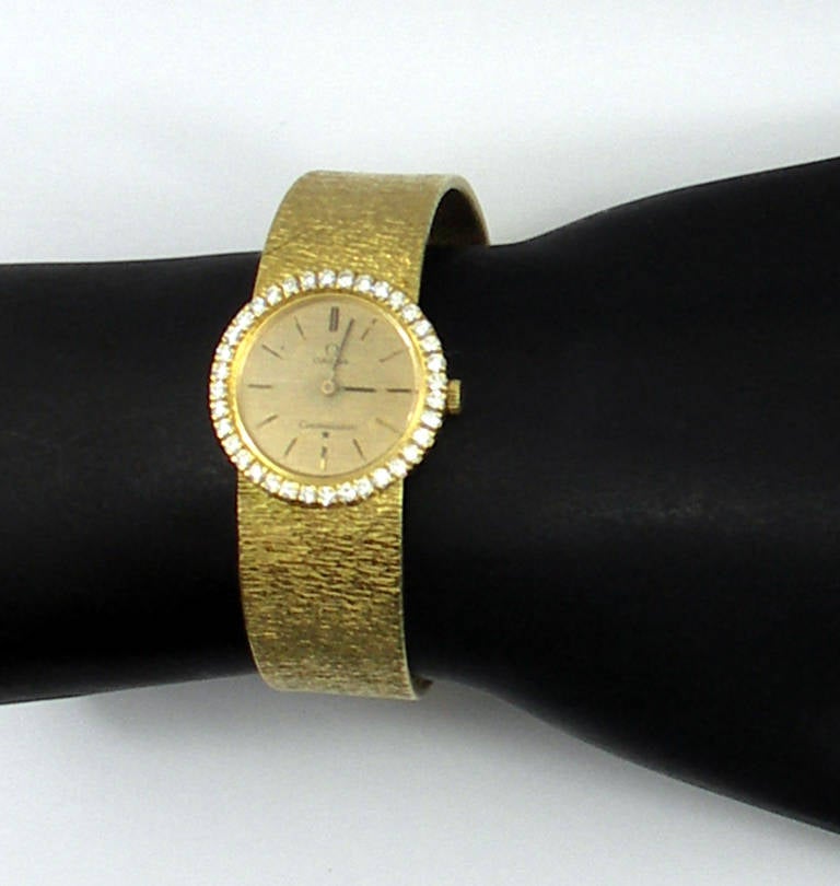 Omega lady's 18k yellow gold Constellation wristwatch, with 24mm bezel set with approximately 1 ct of round brilliant-cut diamonds, with a bracelet measuring 5/8 of an inch wide.
