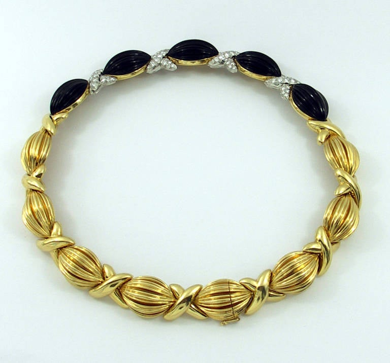 An elegant 18K yellow gold necklace by Charles Turi, with fluted onyx links, and diamond stations. Each link measures 5/8 of an inch wide, with seven links comprised of gold, and 5 links embellished with onyx. Between the gold links are nine gold