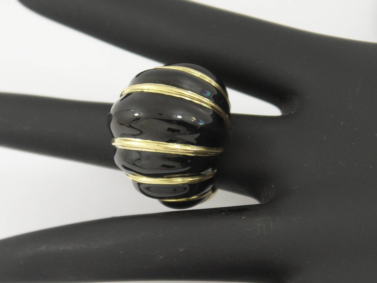 A strikingly contrasting ring in 18K yellow gold upon which are seven cells of beautiful black enamel. Measuring one inch wide, and one inch long, it rises approximately 5/8 of an inch above the finger. Signed Webb for David Webb, it is a size 6.