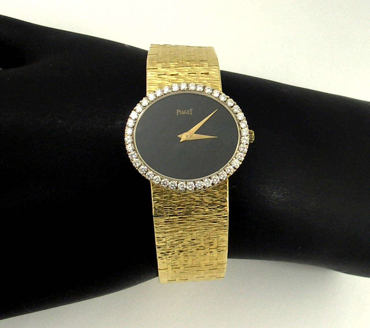 A striking Piaget lady's wristwatch in 18K yellow gold. Featuring an onyx dial. Surrounding the dial is a 24mm X 28mm bezel set with 40 round brilliant cut diamonds weighing approximately 1ct total, of F/G color, and VS1 clarity. Overall length is 6