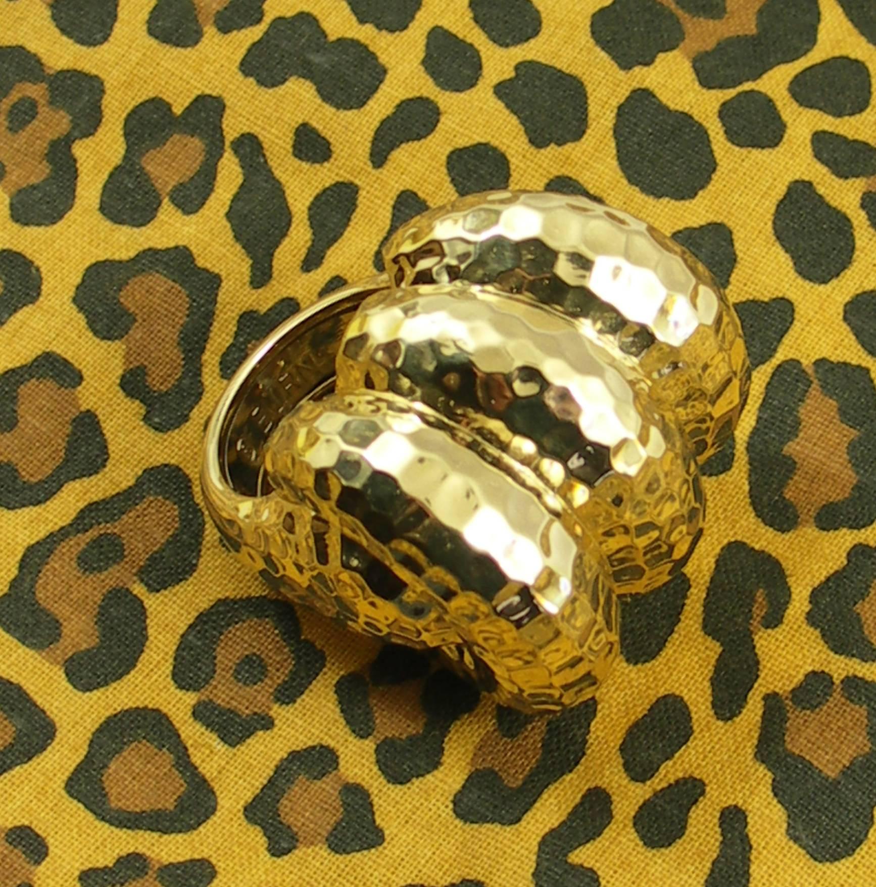 A Large ring measuring 1 inch long, 1 1/4 inches wide, and rising 2/3 of an inch above the finger. A hammer finish is added to this 18K yellow gold ring, to give it a rich golden appearance.