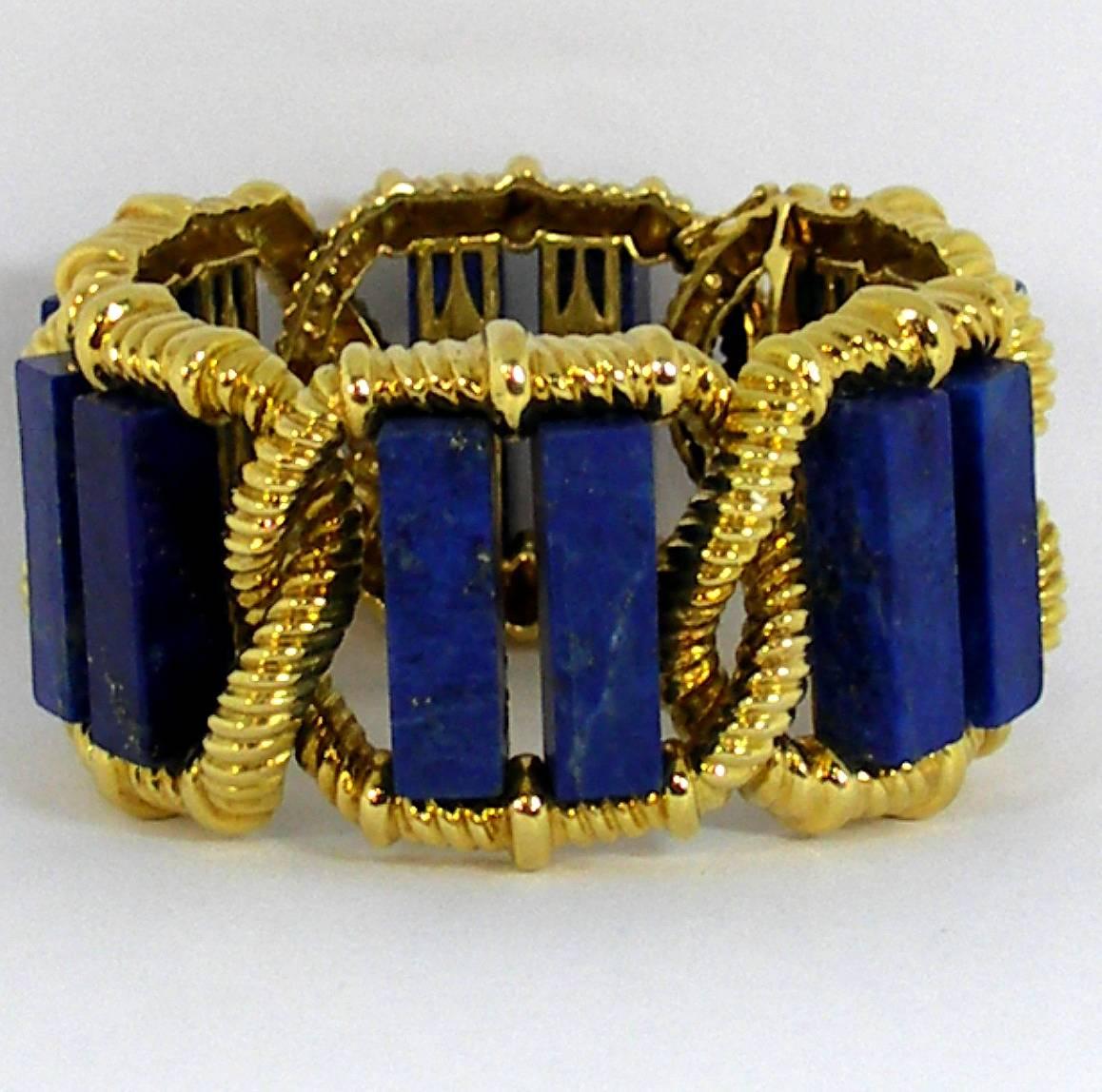 An 18K yellow gold bracelet by Wander of France, measuring 1 3/8 inches wide, and embellished with 12 slabs of Lapis Lazuli. Each link is comprised of a twisted rope design with two columns of Lapis.
