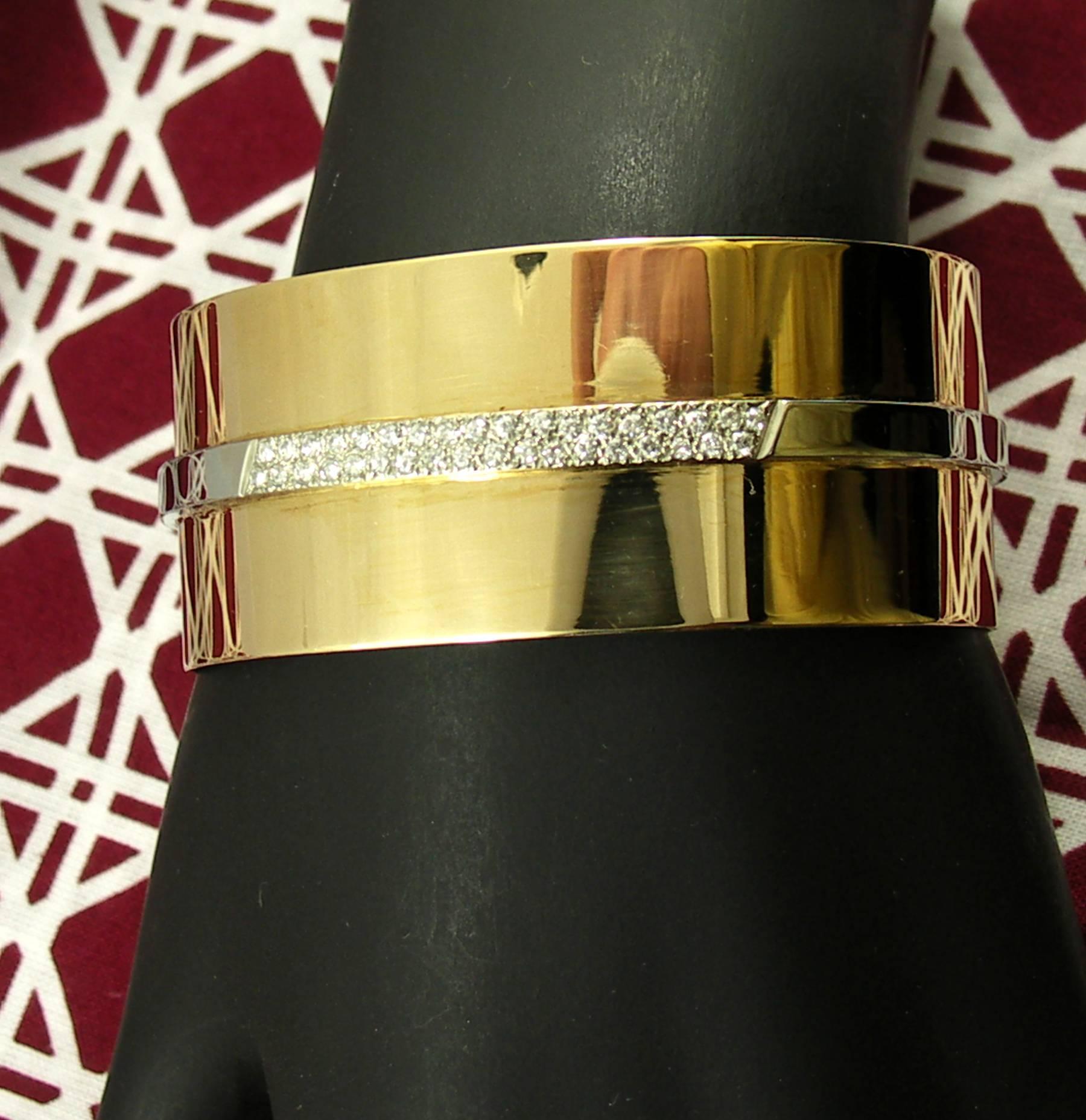 A bracelet by Cartier, constructed in 18K yellow gold with a white gold
strap across the center, set with 36 round brilliant cut diamonds weighing an 
approximate total of .65CT, of overall F color and VS1 clarity. Signed Cartier
and numbered