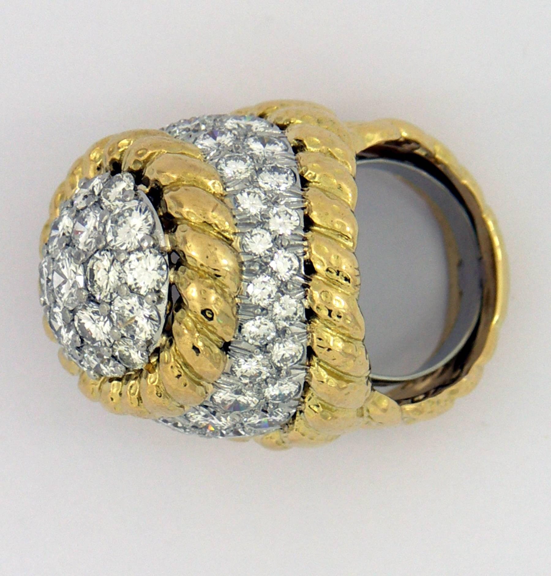 A grand scale ring by David Webb, comprised of an 18K yellow gold frame of twisted rope design, and platinum galleries. It is set with approximately 6ct of overall F color, and VS1 clarity diamonds.
Ring Size 6 1/2