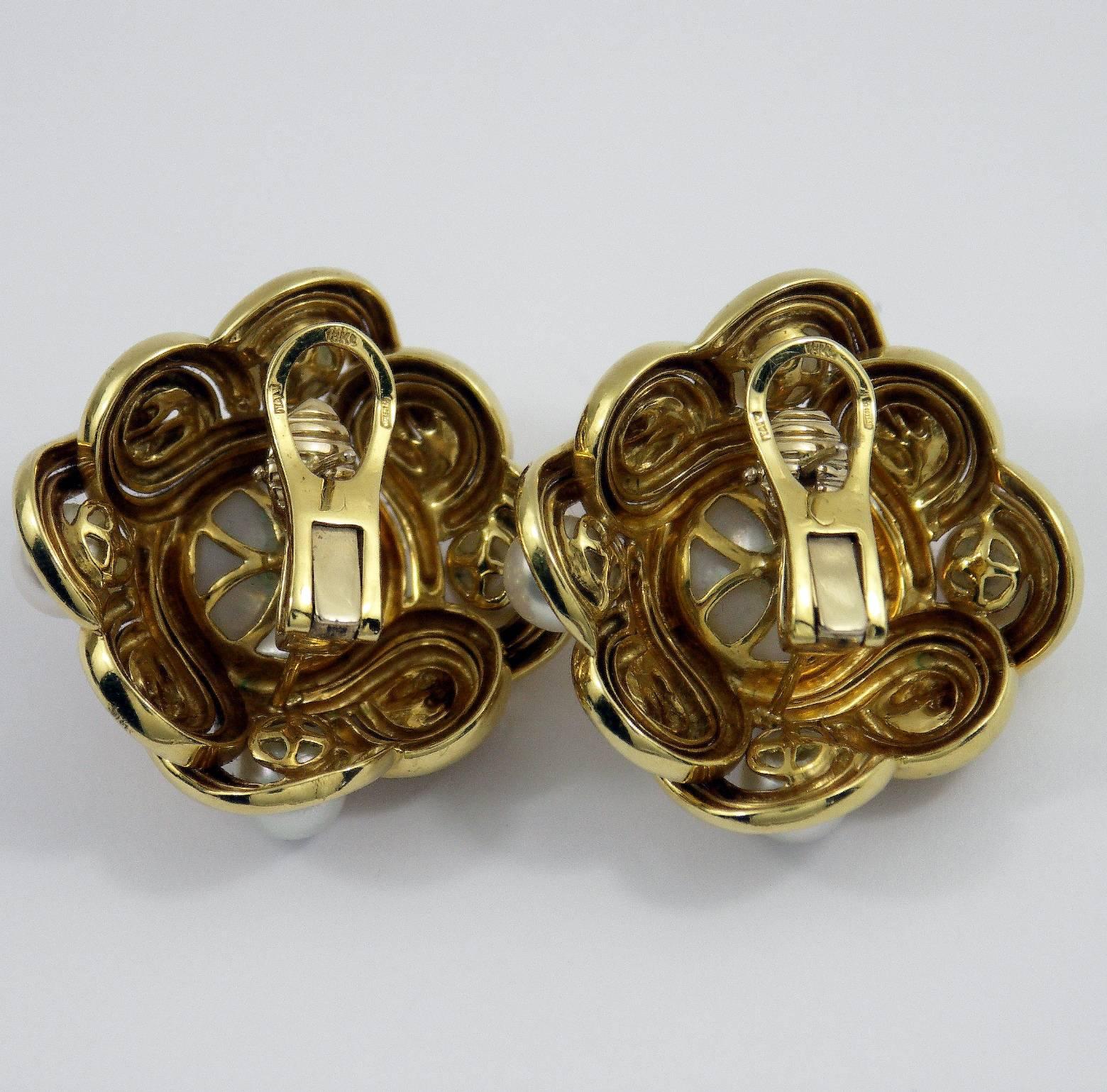 A pair of 18K yellow gold earrings featuring a knot inspired, woven design, with Italian hallmark, denoting manufacture in Alessandria. Each earring measures 1 3/8 inches long by 1 3/8 inches wide, and is set with 4 cultured pearls measuring 7mm,