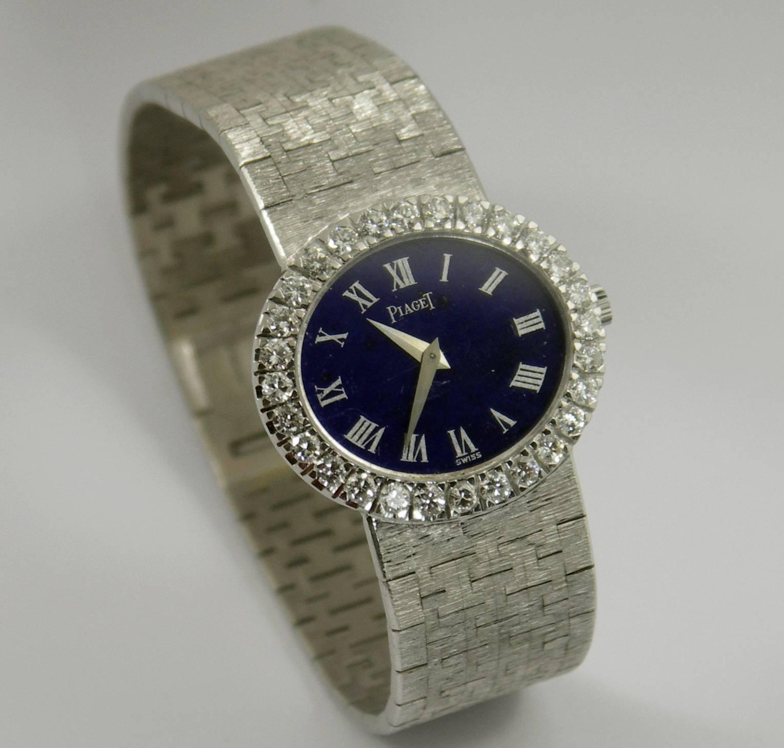 A lady's 18K white gold Piaget wristwatch with a deep blue, lapis lazuli dial with Roman numerals. Surrounding the case is a bezel measuring 20mm X 26mm, and set with 28 round brilliant cut diamonds, weighing 2.50ct total approximate weight. Overall