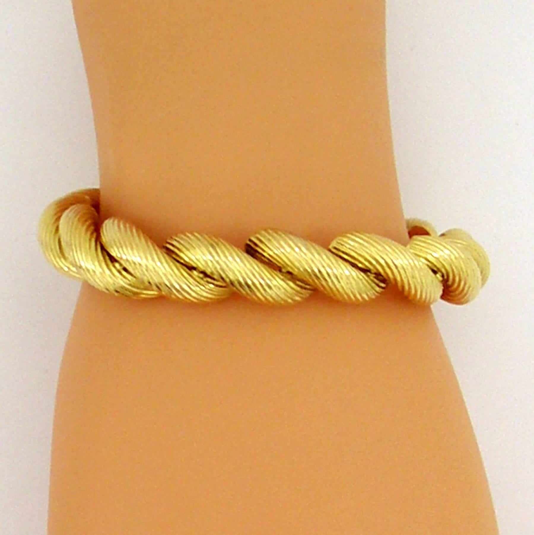 An 18K yellow gold bracelet by Tiffany and Co. comprised of 14 yellow gold links, and an additional link featuring a hidden clasp. Each link of this "macaroni" bracelet features a twisted finish. Will accommodate wrists up to 6 3/4 inches.