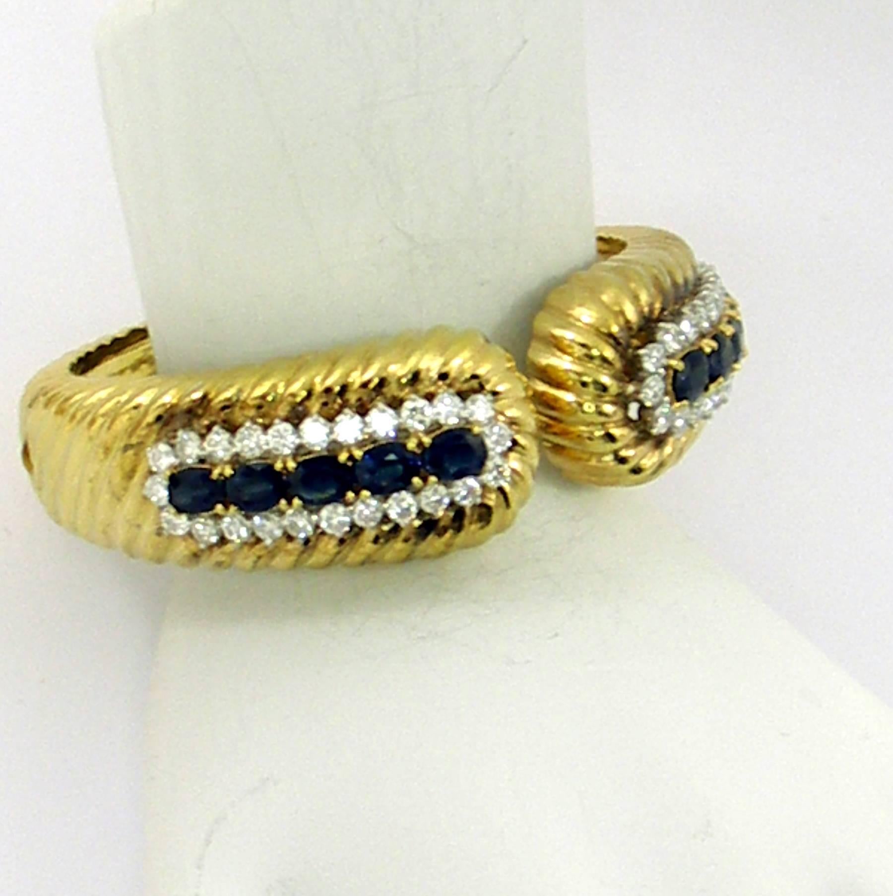 An 18kt yellow gold bracelet tapering in width from 3/4 of an inch, down to 3/8 of inch at the base. Bracelet is set with 48 round brilliant cut diamonds weighing 3.33ct total approximate weight, and 10 oval faceted sapphires for a total weight of