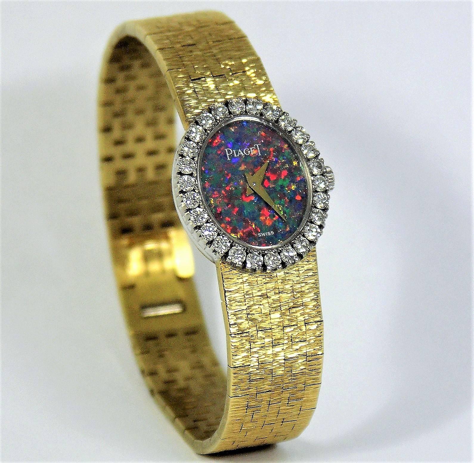This lovely  petite size Piaget, has a vertical, opal dial surrounded by
26 round brilliant cut diamonds weighing an approximate total of 1.20ct.
The outside measurements of the watch head including the diamond bezel 
are 19mm x 24mm. The18k yellow