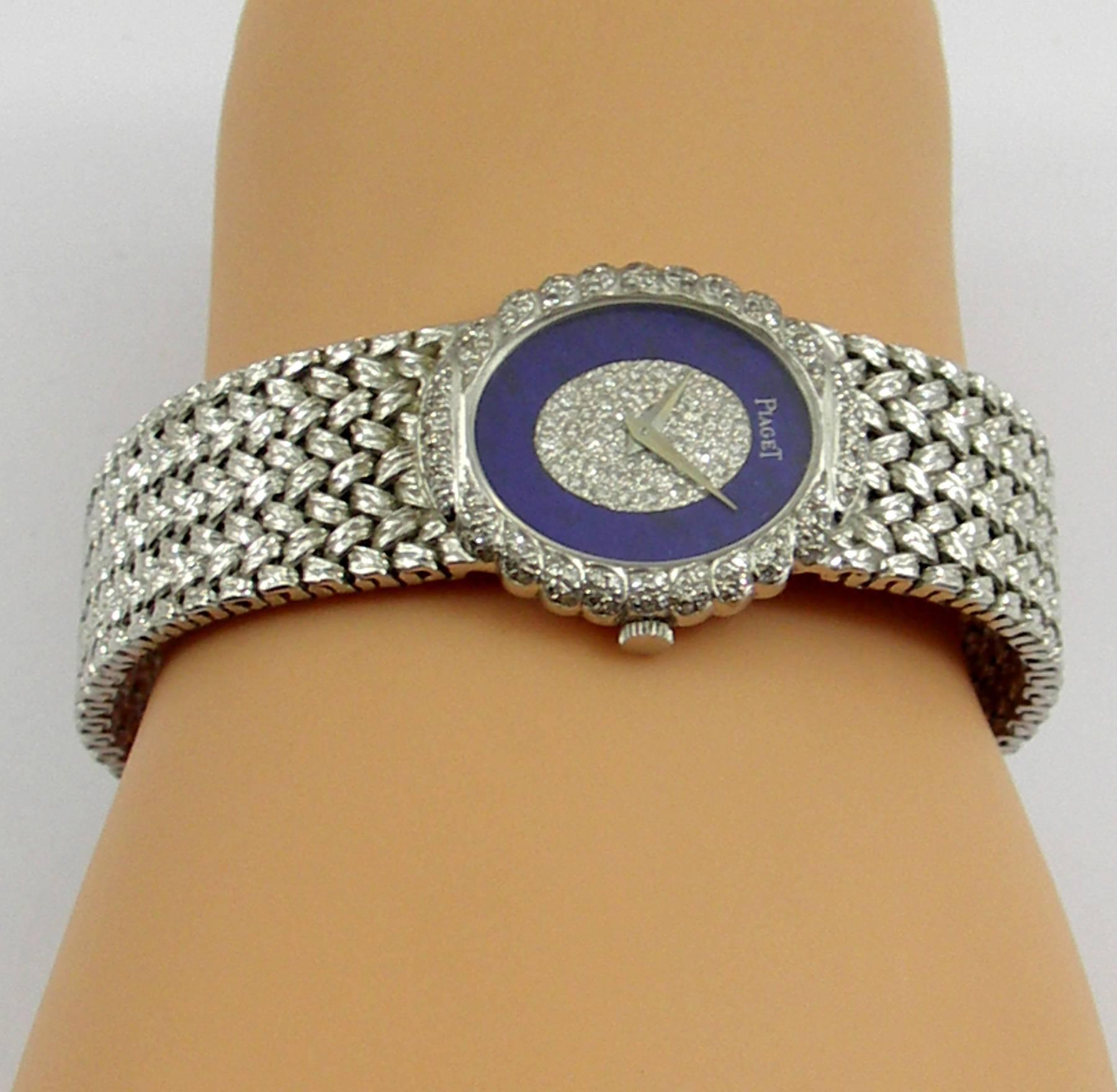 A lady's 18K white gold Piaget wristwatch centered around a unique Dial comprised of an outer ring of lapis lazuli, with the middle of the dial pave' set with diamonds. The bezel features a scalloped edge which is also encrusted with diamonds. Case