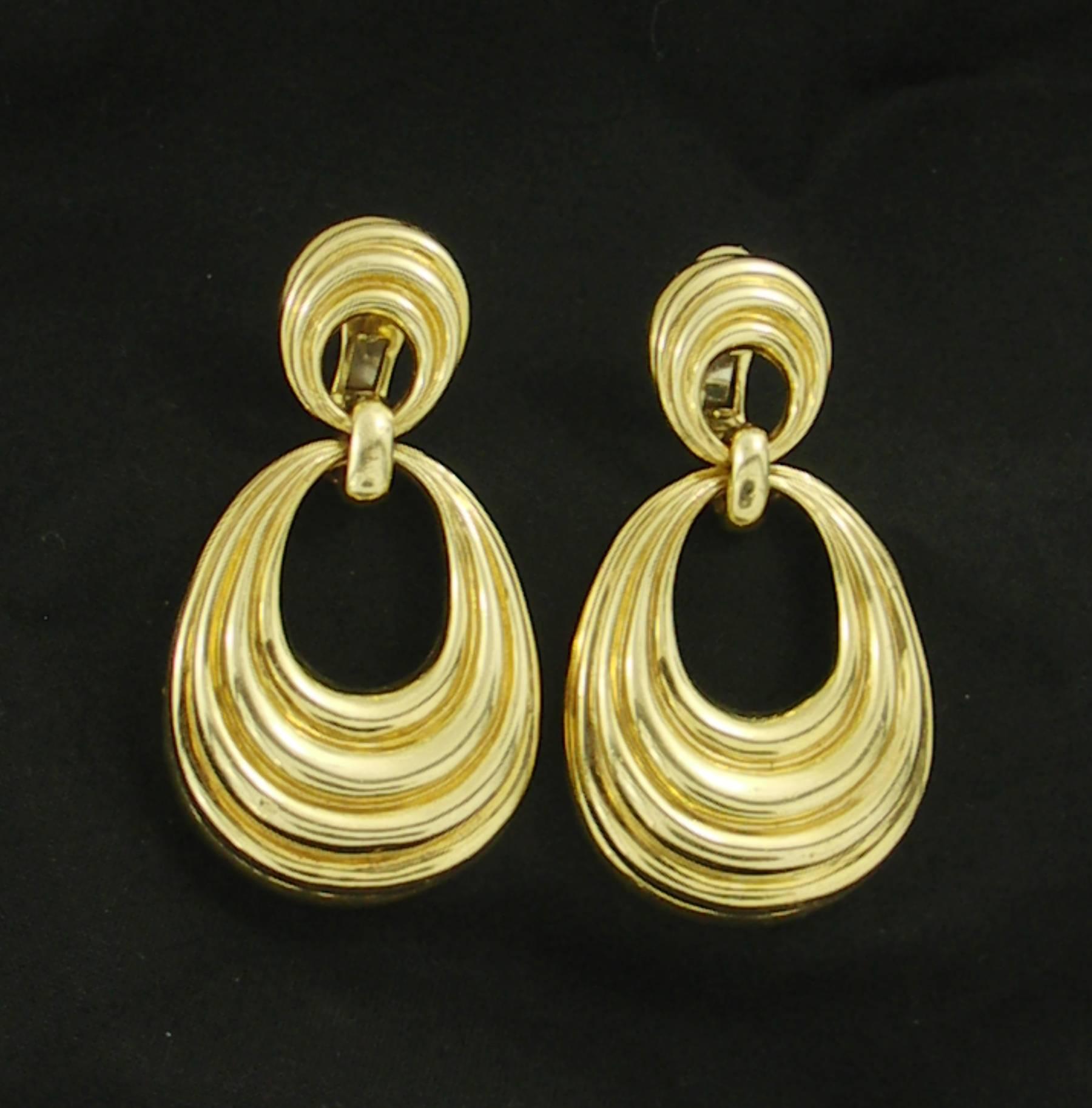 A pair of 18K yellow gold hanging earrings, with a swag design, and high polished finish. Measuring 2 1/2 inches long, they are sleek, and sophisticated. Signed David Webb