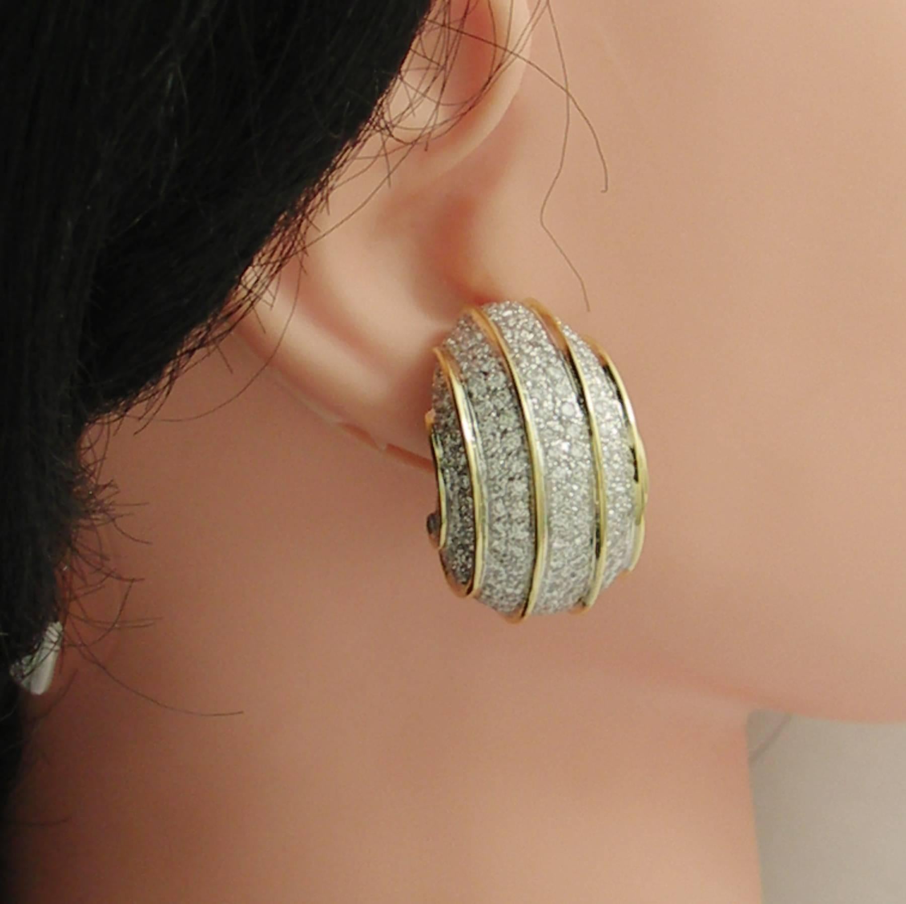 A pair of 18K yellow and white gold earrings measuring approximately 13/16 of an inch wide, and 1 1/4 inches long. These Deco inspired earrings feature a bombe design in white with yellow pin stripe detail. They are pave set with 464 round brilliant