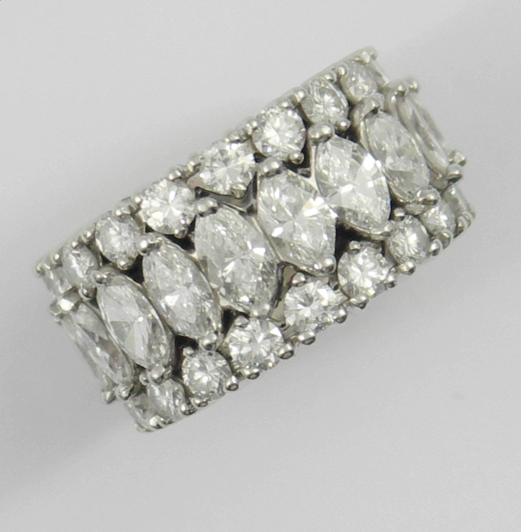 One ladies platinum band set with 23 marquise cut diamonds weighing 3 carats total approximate weight, and 50 round brilliant cut diamonds weighing 3 1/2 carats total approximate weight. This stunning ring tapers in width from 7/8 of an inch, down