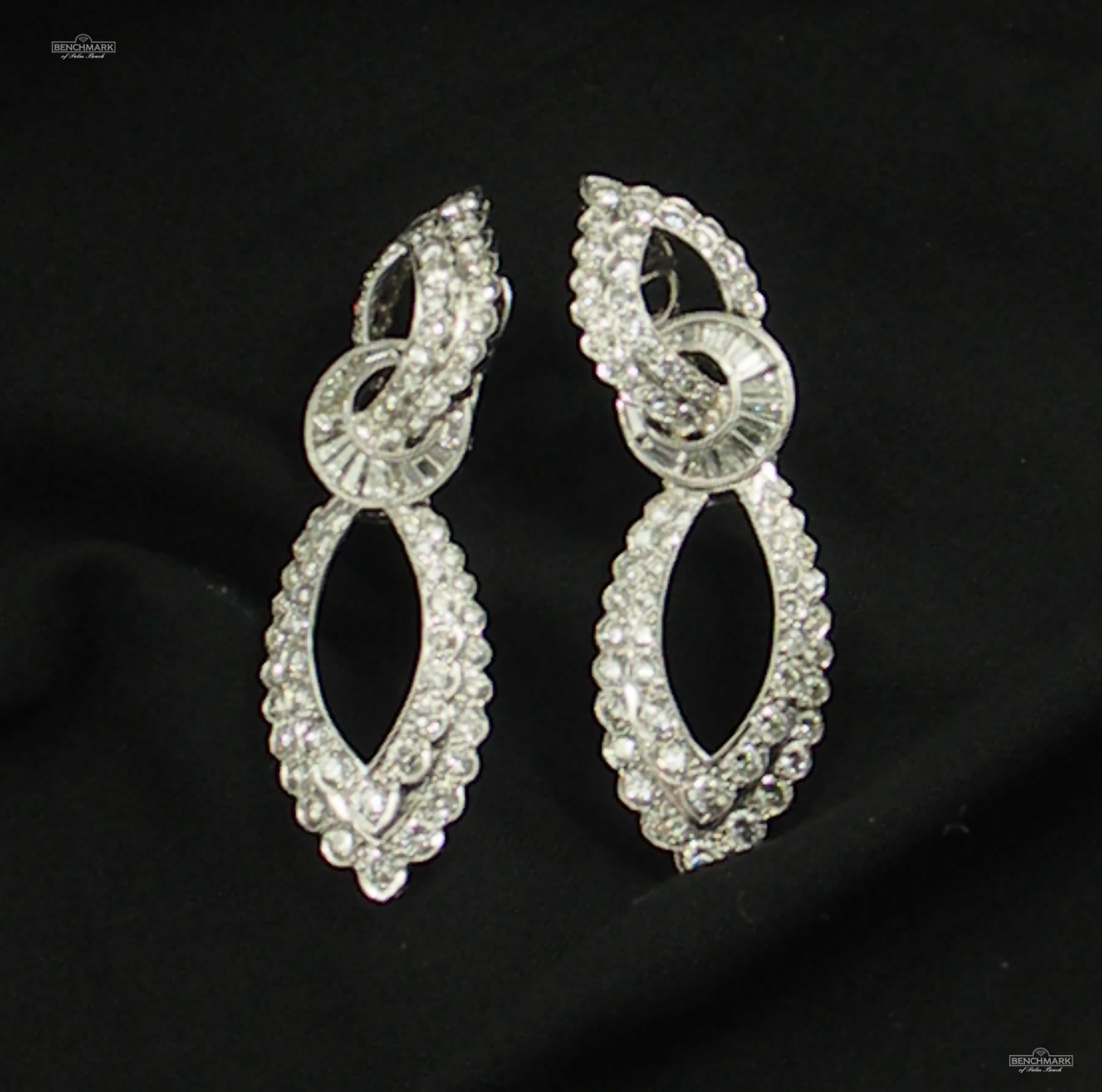 A pair of 18K white gold earrings with an almost Edwardian feel that hang on the ear wonderfully, and are set with round brilliant cut and baguette cut diamonds. They are comprised of a flattering top and bottom set with round diamonds joined by an