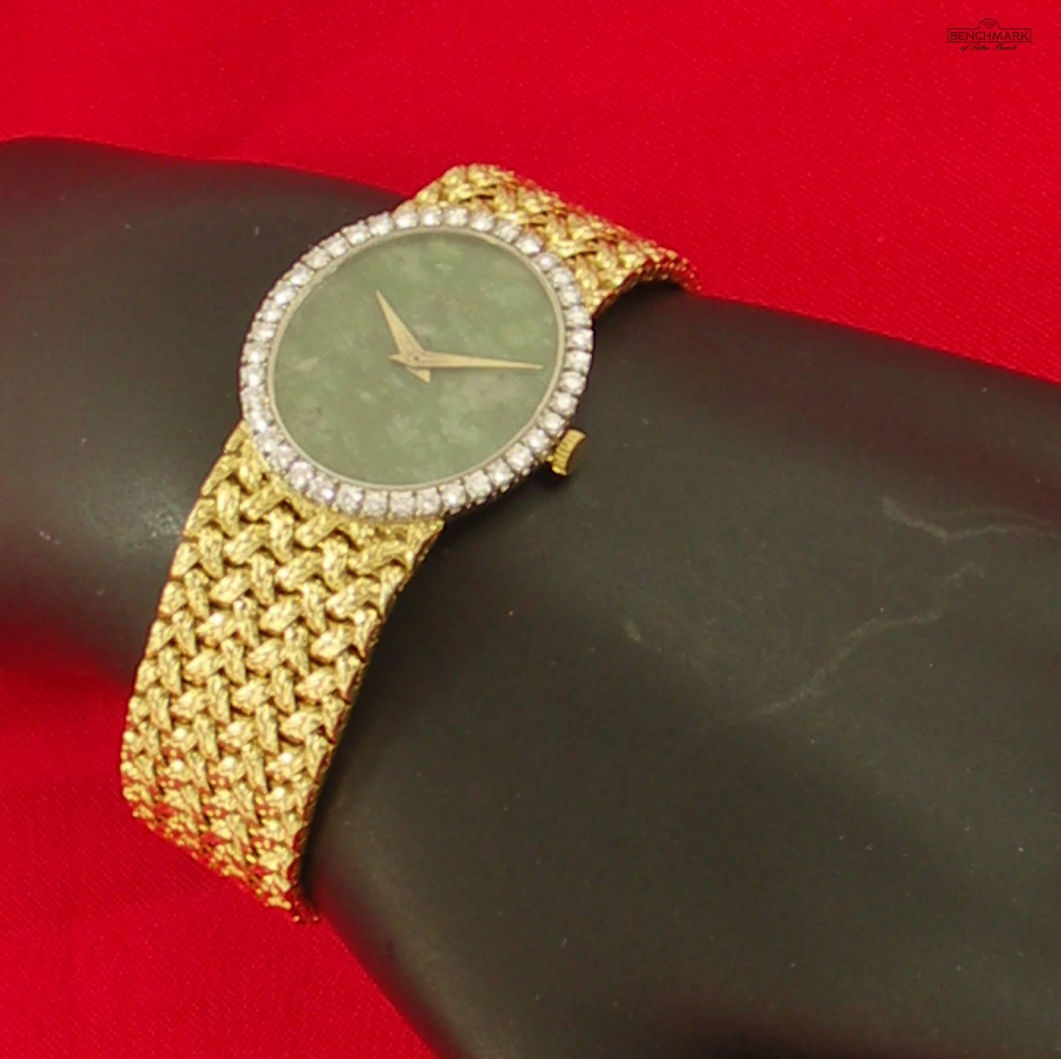 One ladies 18K yellow gold wristwatch with a woven bracelet, and centered around a vertical oval green jade dial. The bezel is comprised of 40 round brilliant cut diamonds weighing 1ct total approximate weight, utilizing four prong settings. The