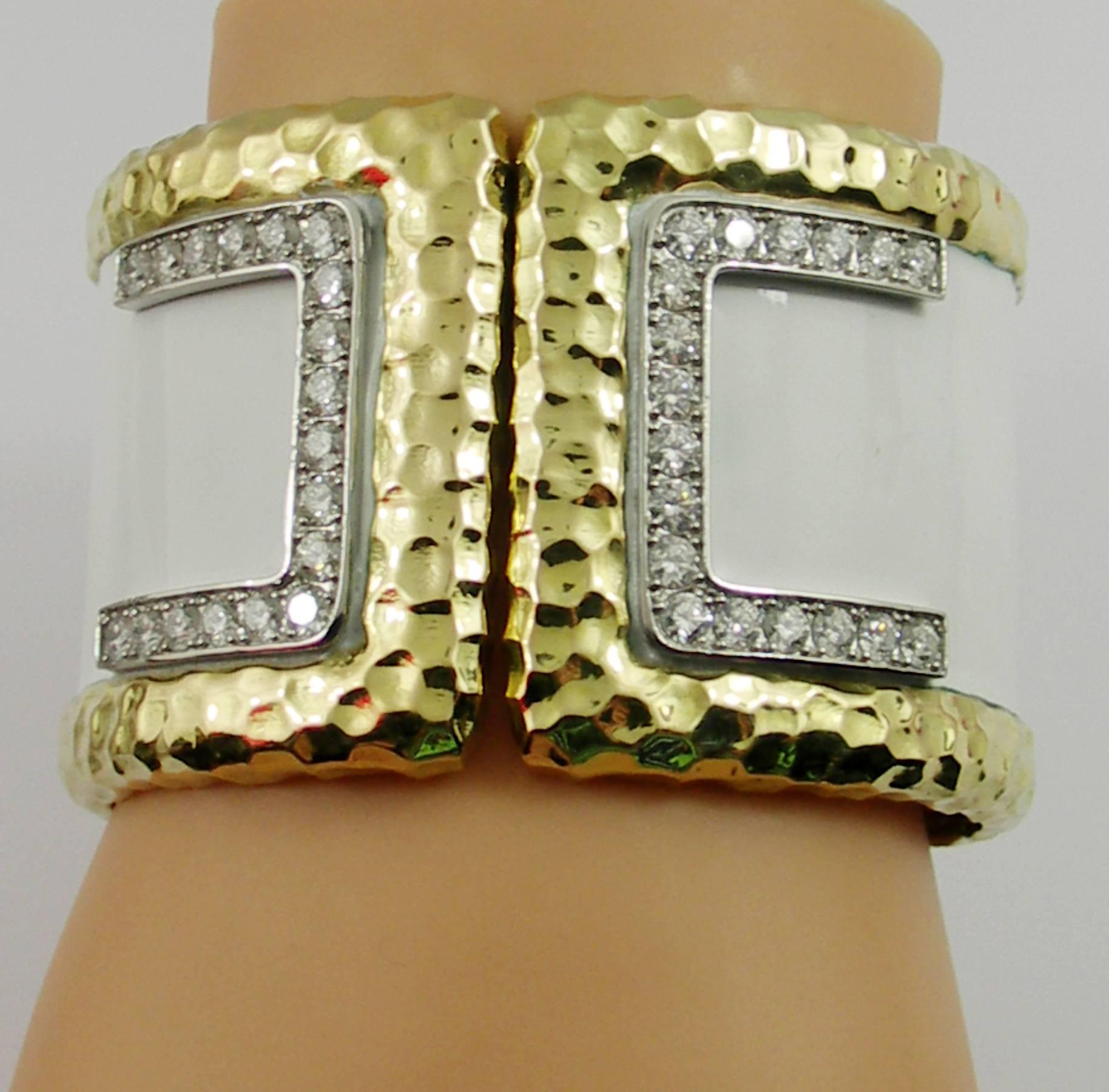 One ladies 18 karat yellow gold cuff bracelet featuring a hammered edge with inset white enamel, and measuring 1 3/4 inches wide. With a split front design, this  bracelet  is set with assorted round brilliant cut diamonds weighing 5 carat total