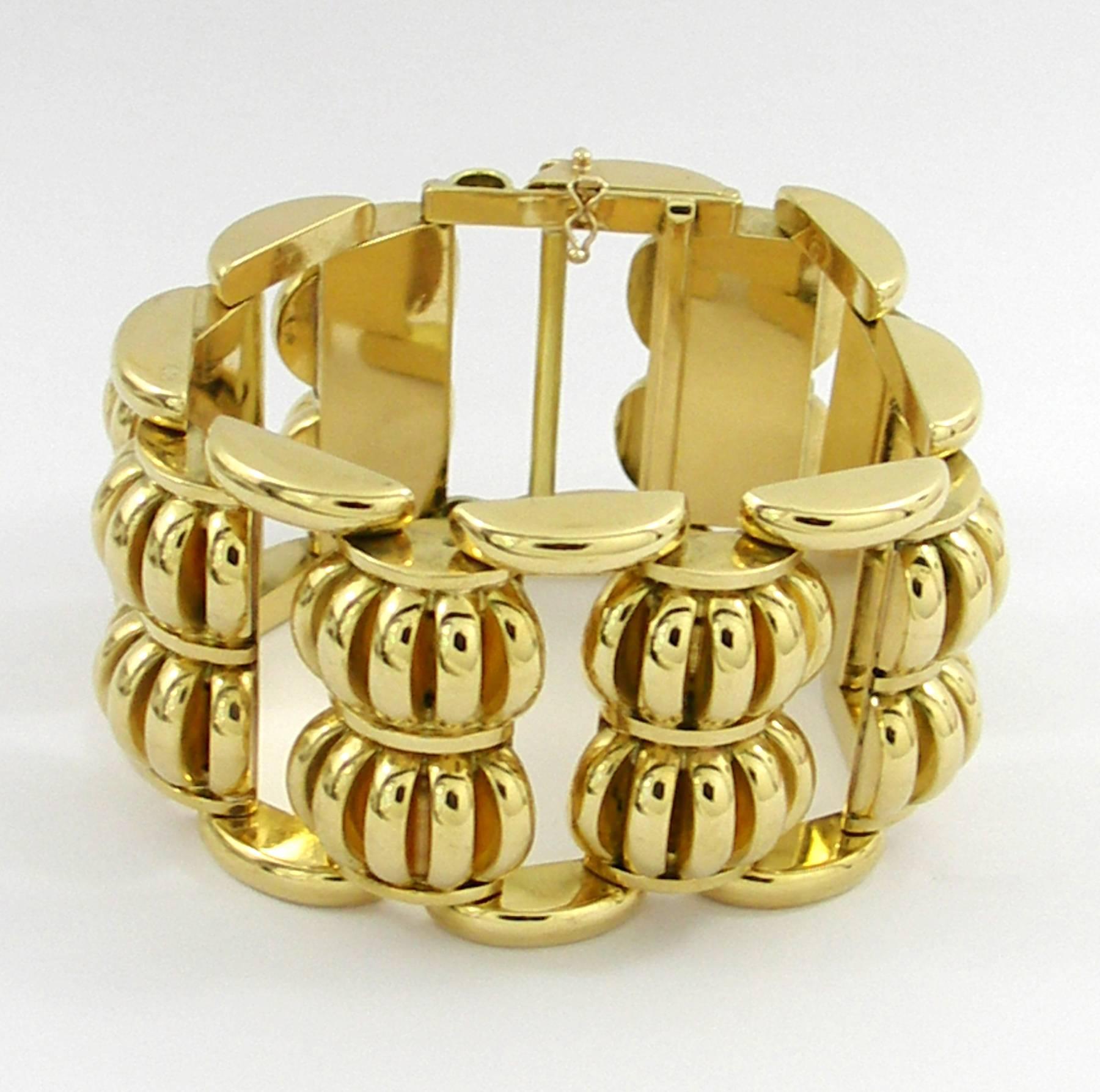 An 18K yellow gold bracelet comprised of half moon links with half disc designs fanning out. Lining the edges and connecting the bombe' links are half oval connectors. Each connector stands 3/8 of an inch tall, while the connectors measure 1/4