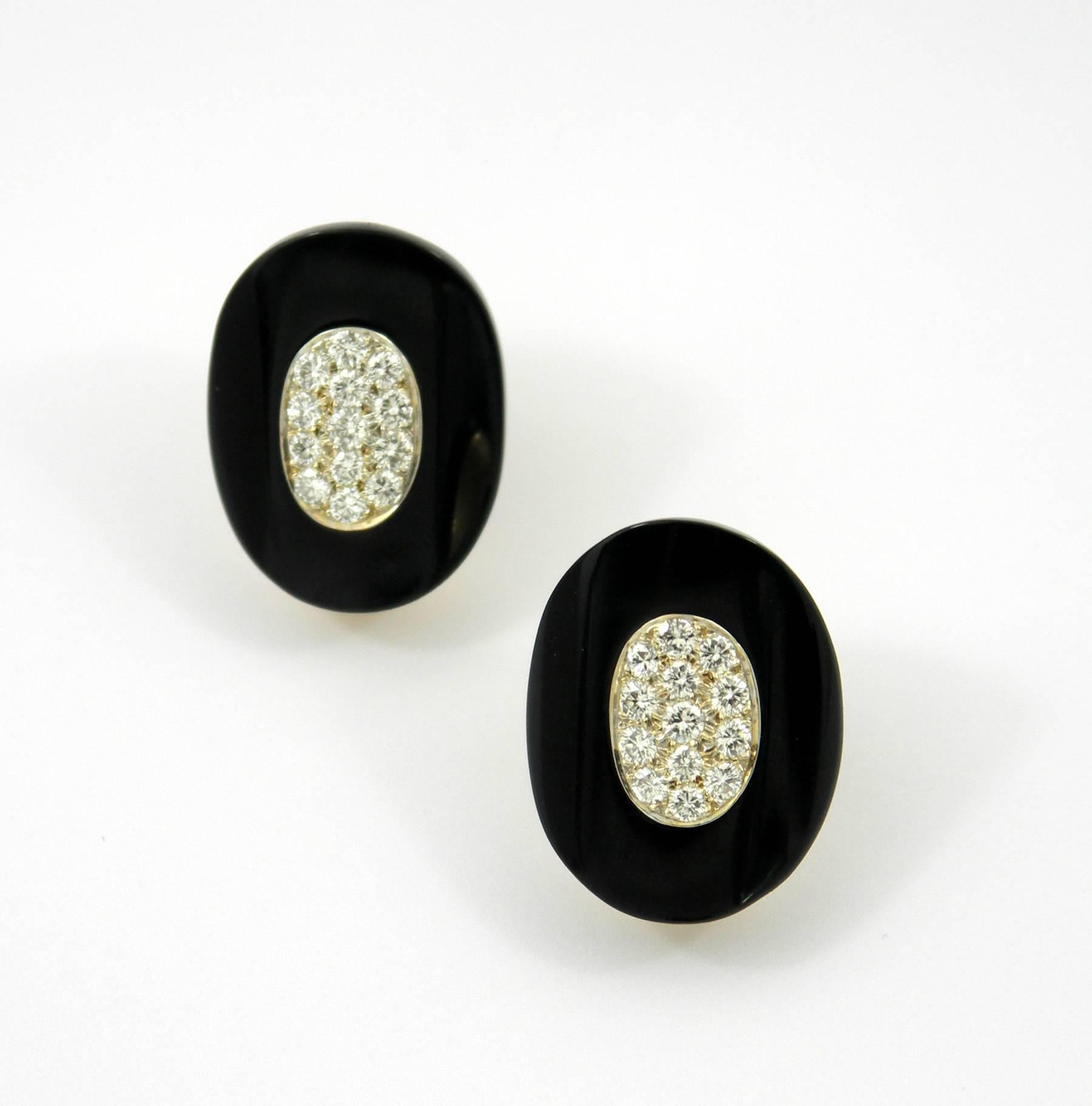 Elongated oval earrings, each centered around 15 pave' set, round brilliant cut diamonds, surrounded by a ring of onyx. Diamonds weigh a total of approximately 1.33ct of overall E/F color and VVS2/VS1 clarity. Each earring measures 1 inch long, and