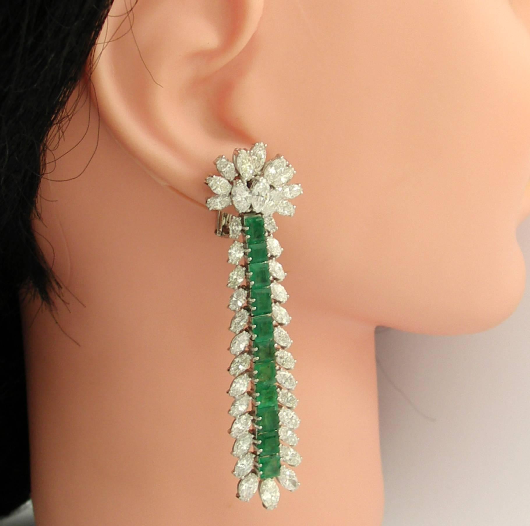 A pair of ladies platinum mid-century hanging cocktail earrings, set with 78 oval brilliant diamonds weighing a 22ct total approximate weight, and 22 square cut emeralds weighing 5ct total approximate weight. The emeralds are bright and Colombian in