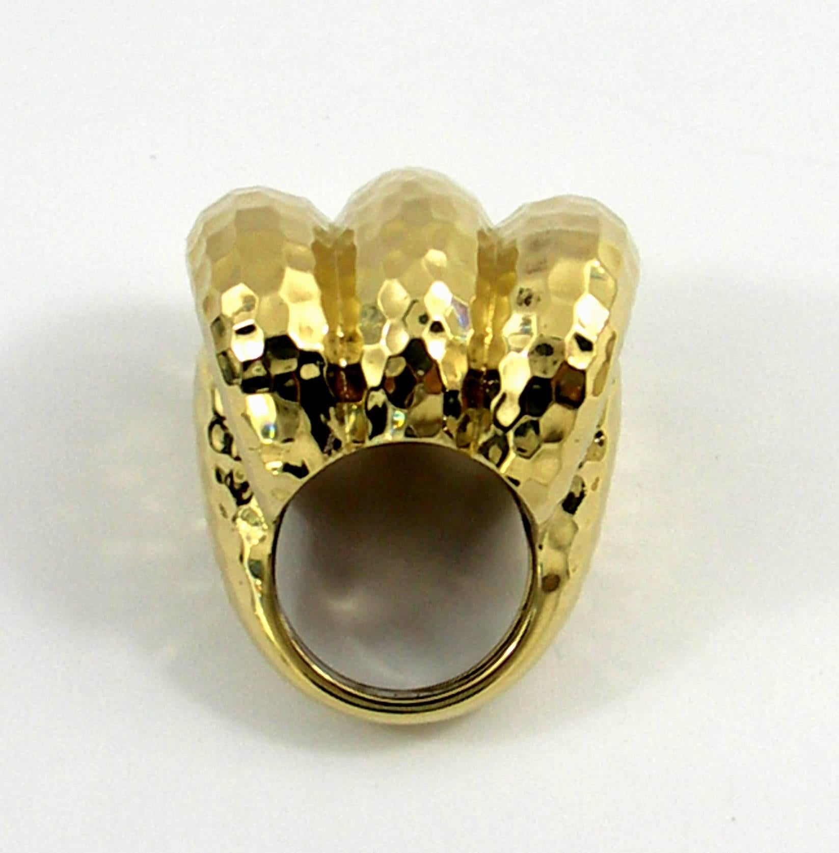 A Large ring measuring 1 inch long, 1 1/4 inches wide, and rising 2/3 of an inch above the finger. A hammered finish is added to this three section, 18K yellow gold ring, to give it a rich golden appearance.  Ring is size 6 1/2 and can be sized.  