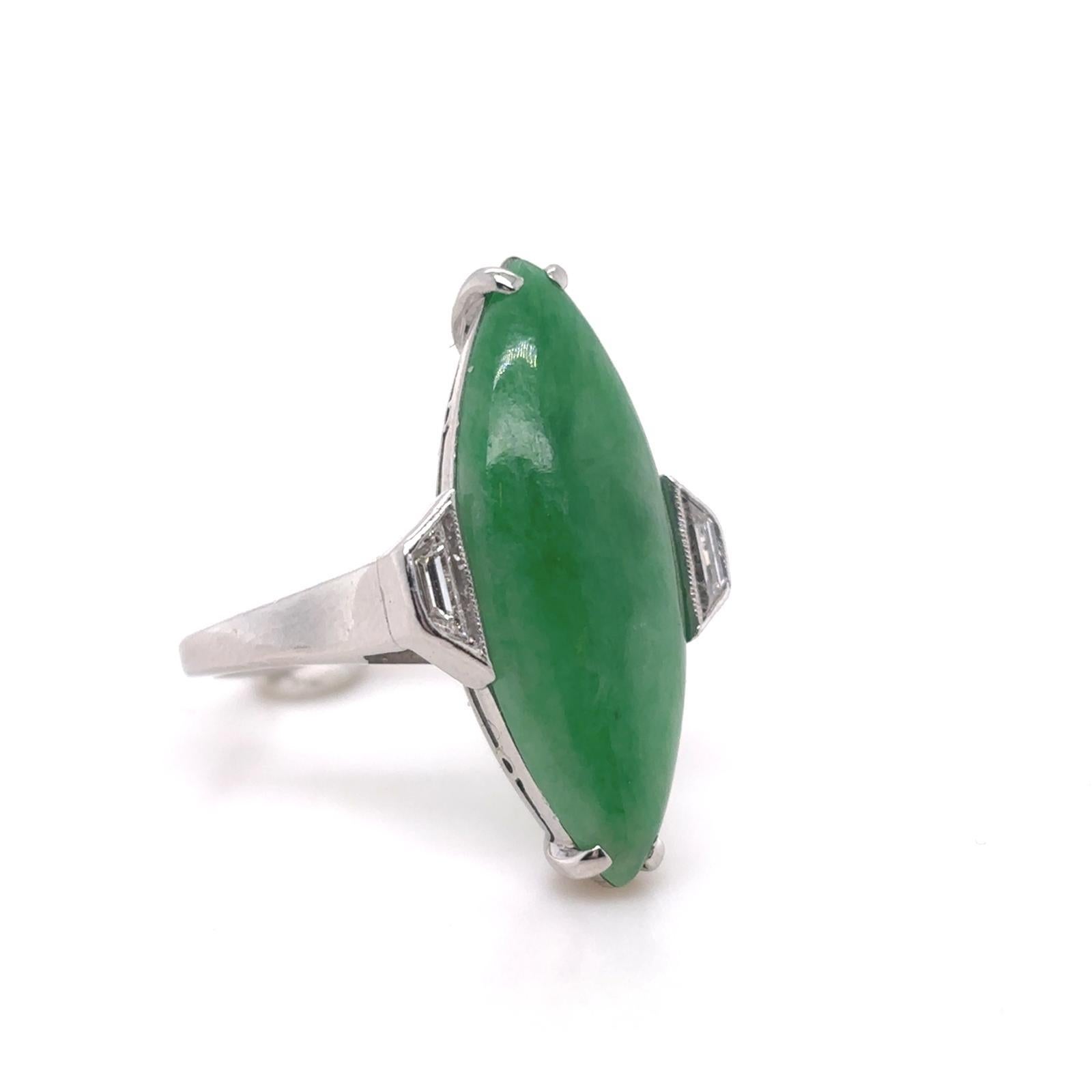 Bague de fiançailles vintage en jade et diamants en platine, vers 1950.

Cette bague présente un cabochon central de jadéite de couleur vert impérial en forme de marquise, serti en platine dans une paire de diamants trapézoïdaux sertis en chaton.