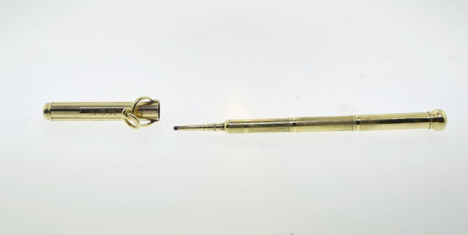 100% guaranteed authentic Tiffany & Co. antique 14k yellow gold telescoping mechanical pencil pendant measuring 2.25 inches closed and 4.25 inches open. The pencil is in great condition, especially considering its age. It is engraved A G M and