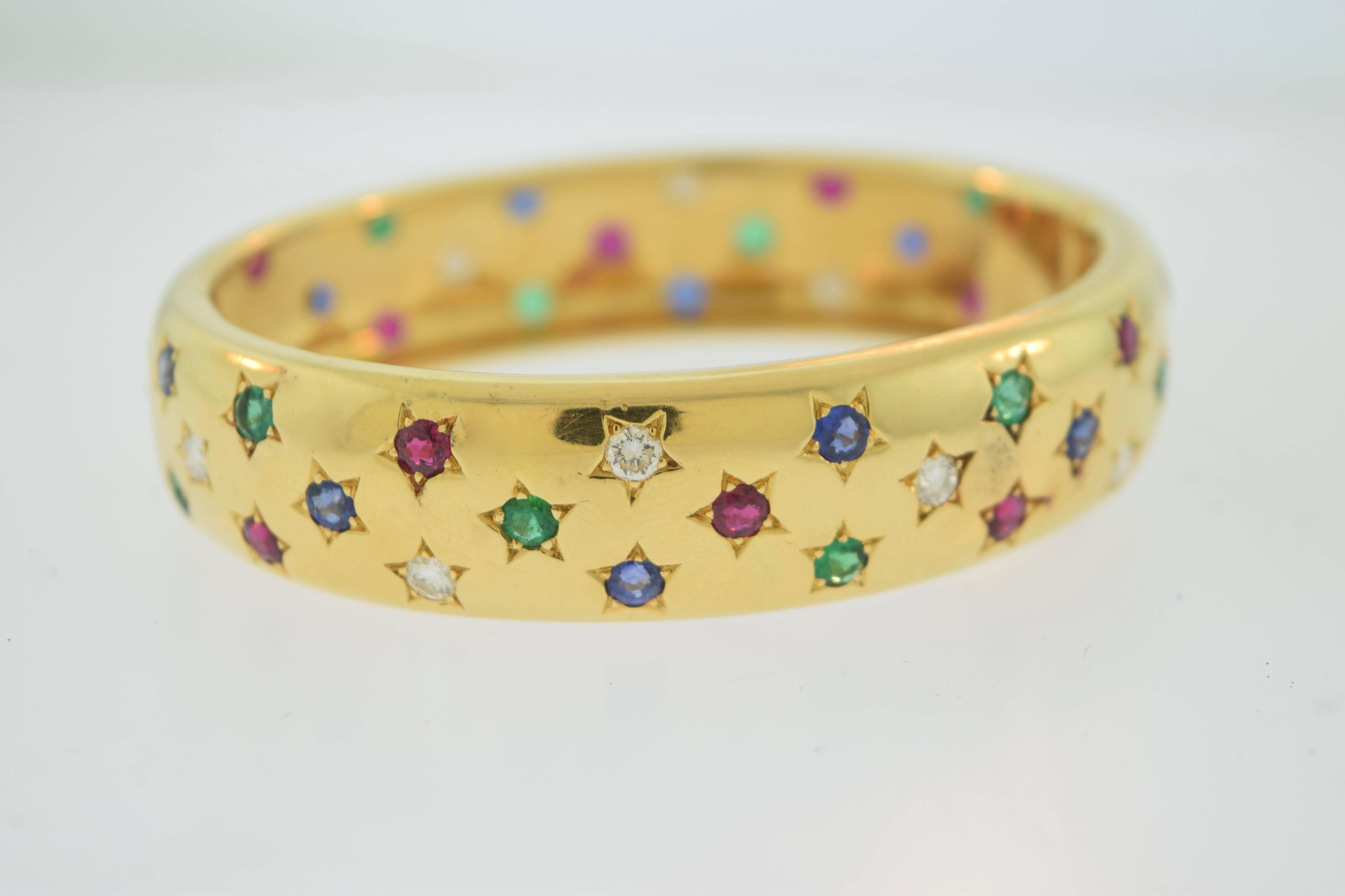 Cartier Vintage Star Gold Bangle

Elegant, modern, vintage, & 100% authentic Cartier bangle, with magnificent diamonds, sapphires, rubies, and emeralds, encrusted in stars along the beautiful bracelet. This item was sold in 1995 at the Cartier
