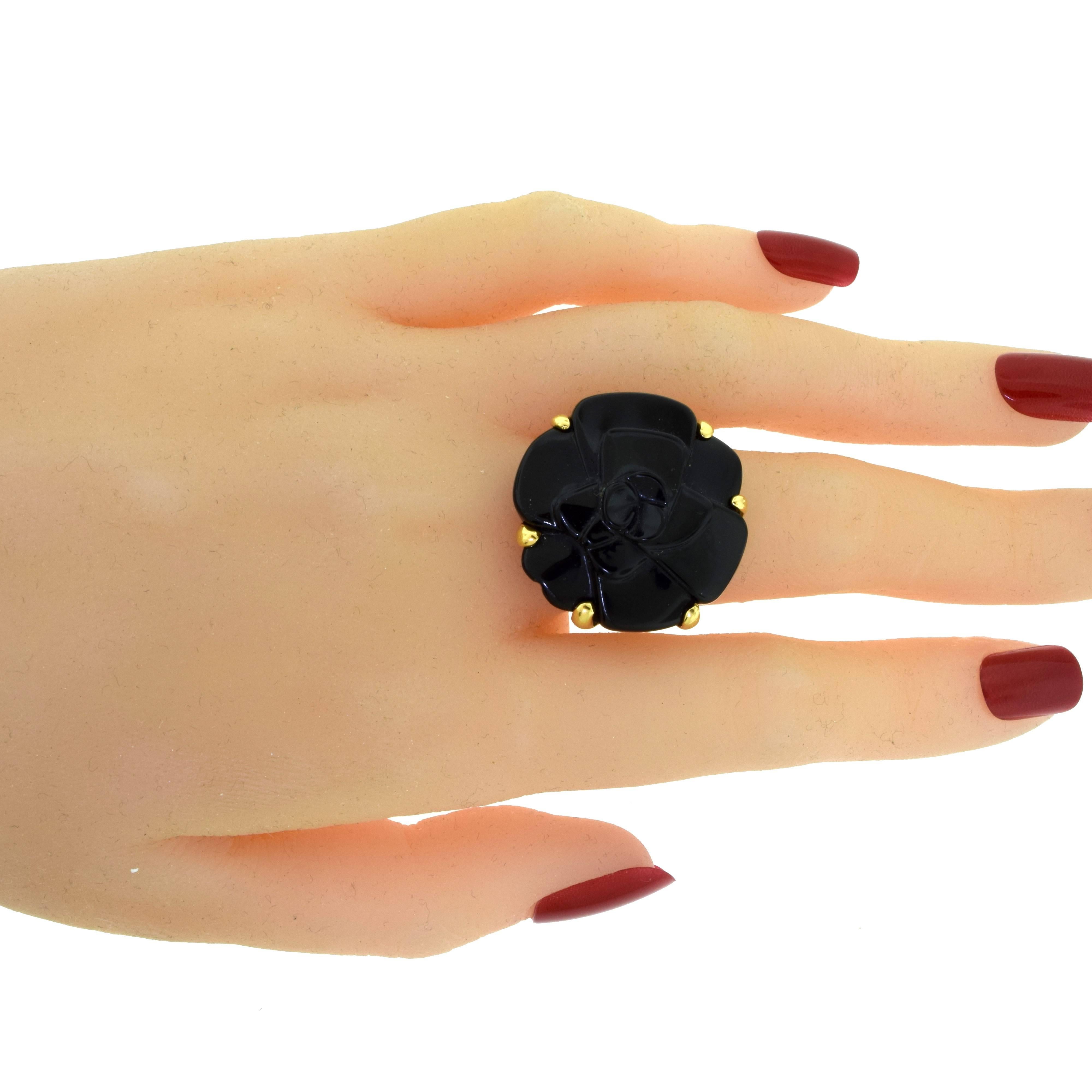 From Chanel's Camellia Collection:

Ring Size: 5.75
Metal: 18 Karat Yellow Gold
Stones: 1 Large Carved Black Onyx Stone
Total Item Weight (g): 14.7
Onyx Dimensions: approx. 24.90 x 25.61 mm
Onyx Thickness: approx. 5.75 mm
Hallmark: CHANEL Serial No.