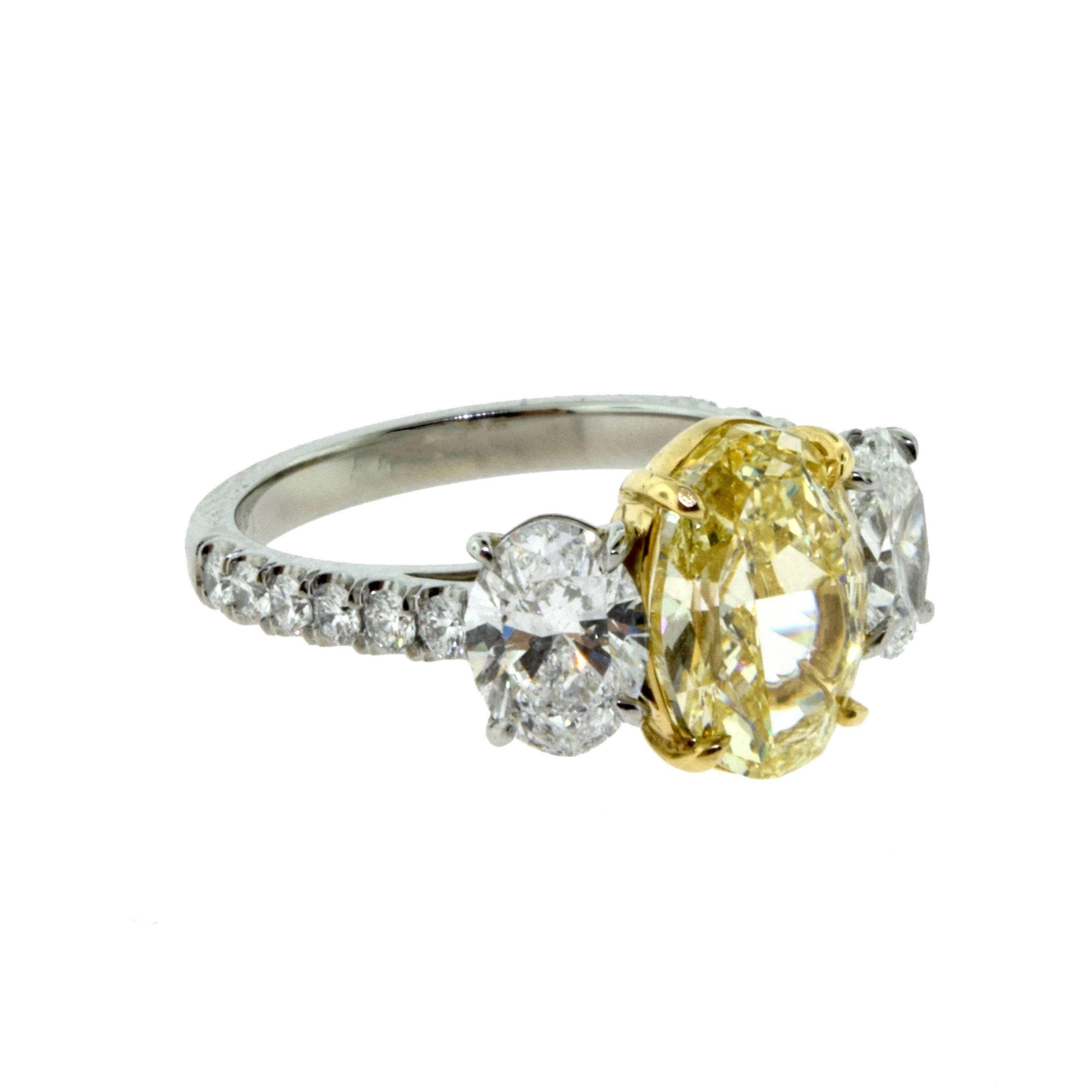 Oval Diamond Three-Stone Engagement Ring with Fancy Yellow Center in Platinum In Excellent Condition For Sale In Miami, FL