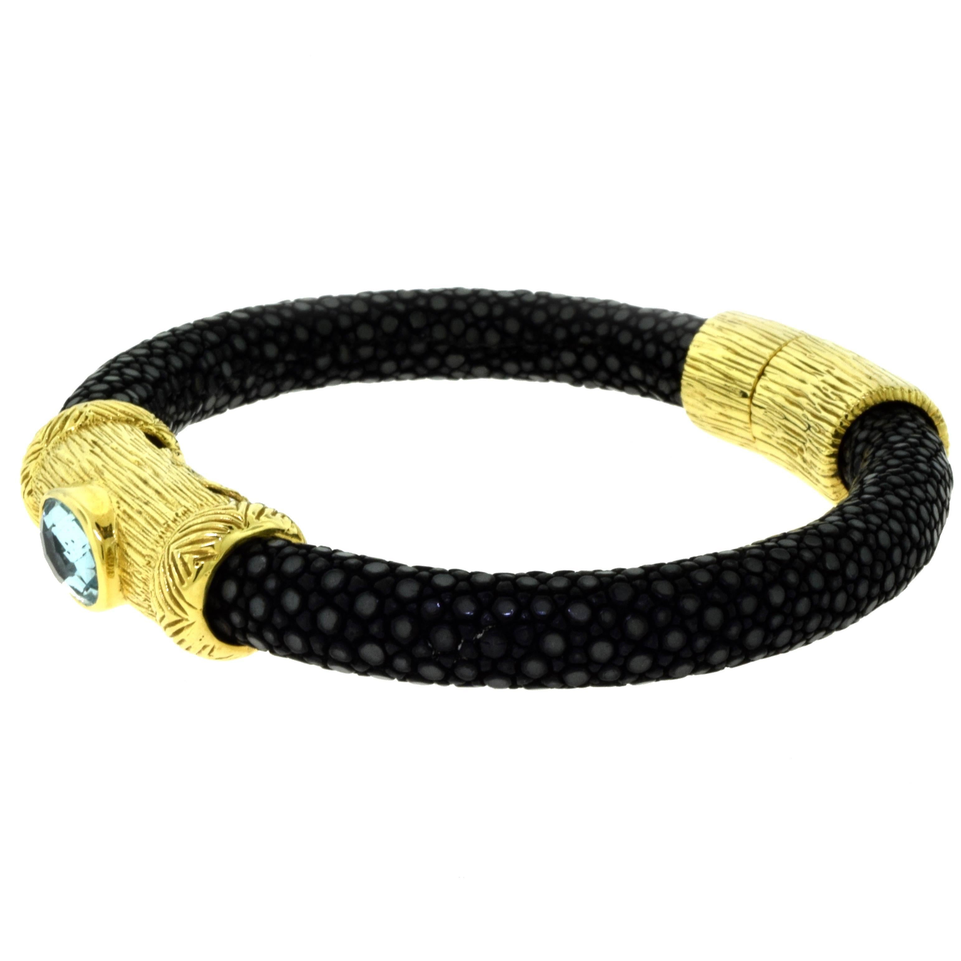 Designer: NINI
Non-Metal Material: Black Snake Skin
Metal: 18 Karat Yellow Gold
Stone: Blue Topaz Oval Stone
Halmark: NINI 18K
Total Item Weight (g): 52
2.75 inches wide
Collateral: Statement of Sale