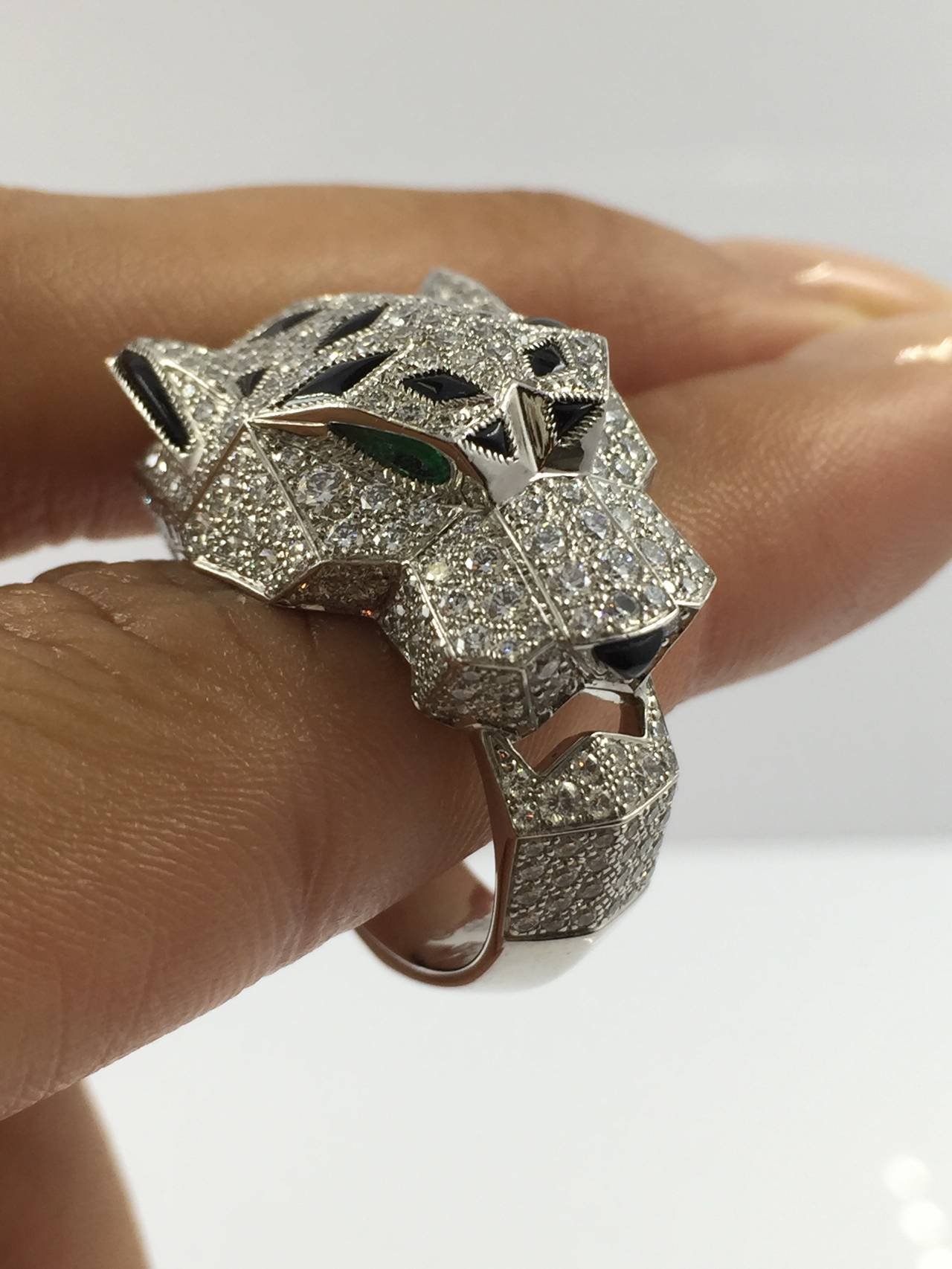 Cartier, A Panther Ring, designed as a sculpted pavé-set diamond panther band, with calibré-cut onyx spots, enhanced by marquise-cut emerald eyes,
 mounted in white gold, signed Cartier, 750, 56 and numbered 91655B, circa 2013. Panthère de