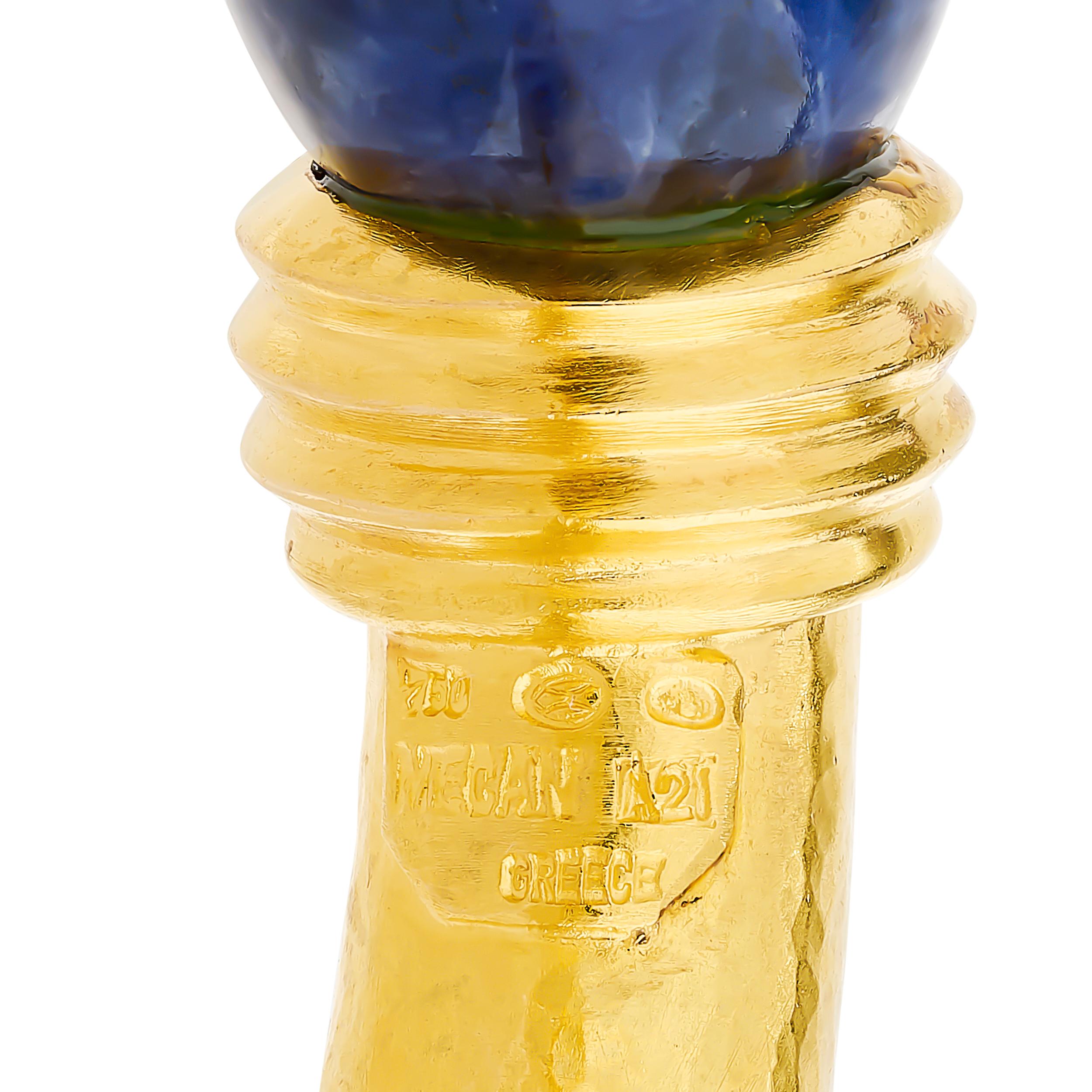Este brazalete Lalaounis de oro amarillo de 18 quilates presenta dos llamativas sodalitas adornando sus extremos abiertos, con detalles texturizados en el oro.

Fabricado en oro de 18 quilates.
La pulsera lleva el sello: 