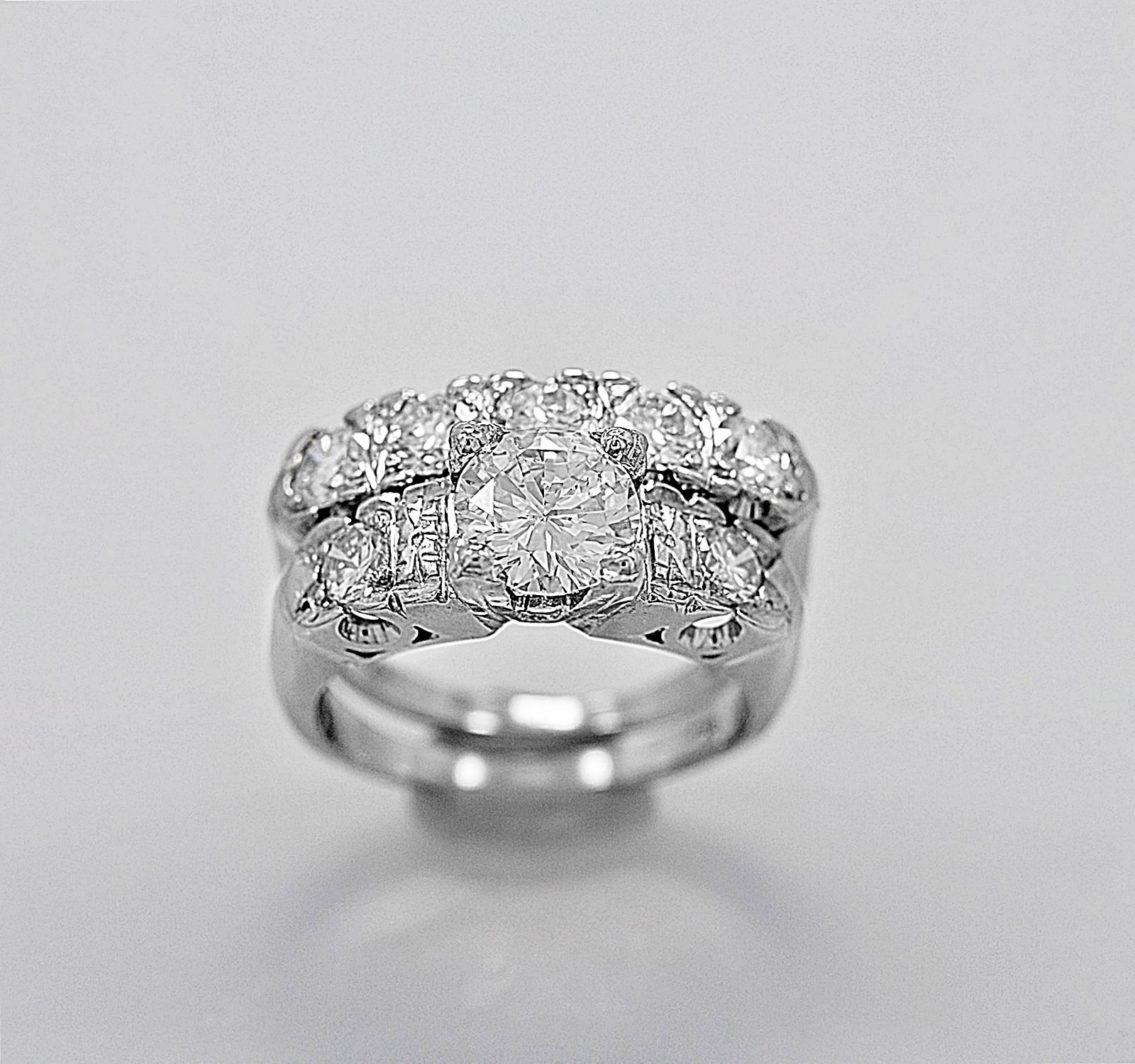 A beautiful and bold looking estate wedding set that features a 1.03ct. apx. center diamond with SI1 clarity and H color. The additional round brilliant diamonds on the mounting and wedding band weigh 1.12ct. apx. T.W. with VS1-VS2 clarity and G-H