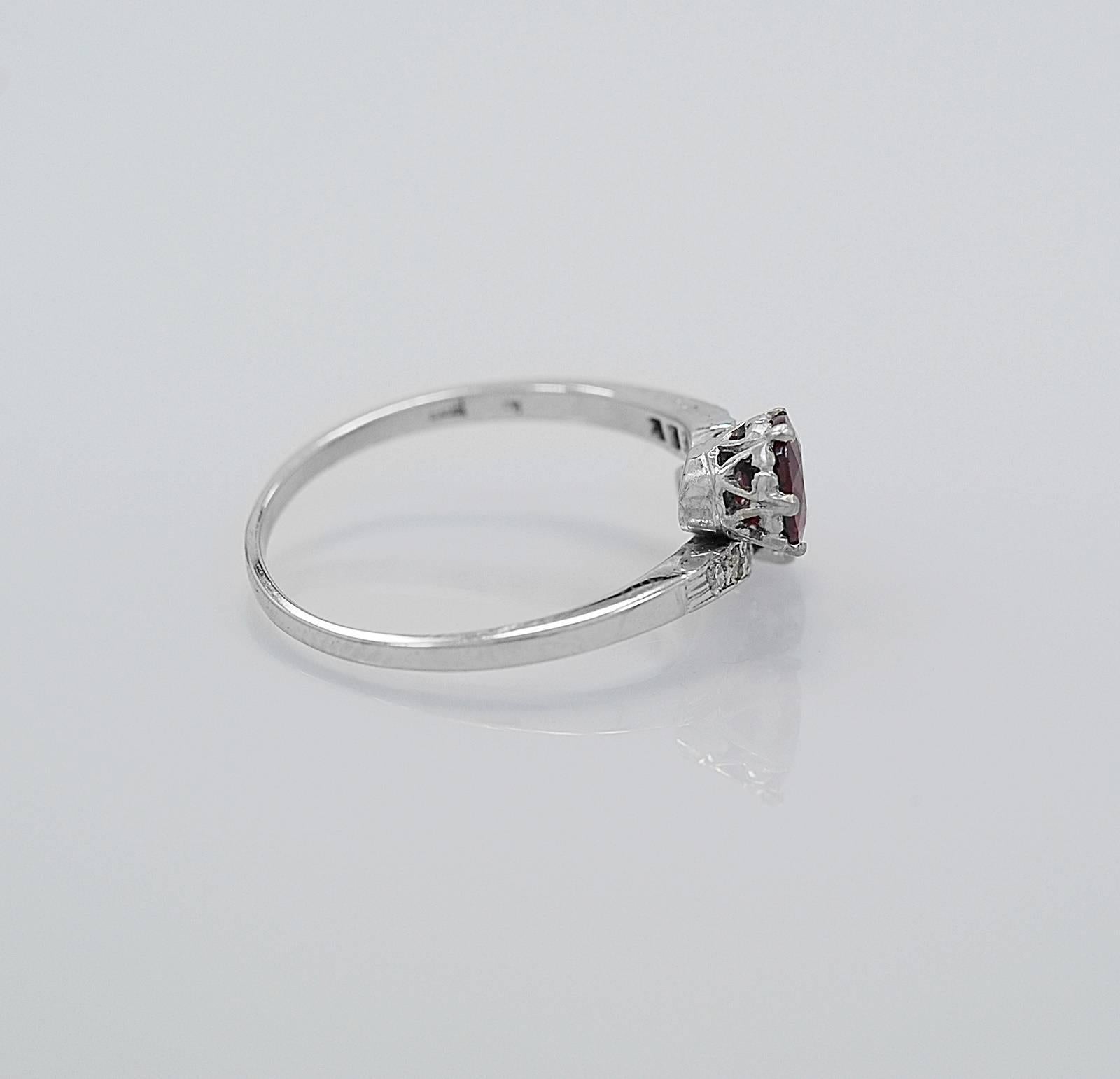 A beautiful low profile antique fashion ring featuring a .80ct. apx. antique round natural ruby bypassing a .55ct. European cut diamond. Small single cut diamonds decorate the head of the bypass mounting adding sparkle and light. This ring would be