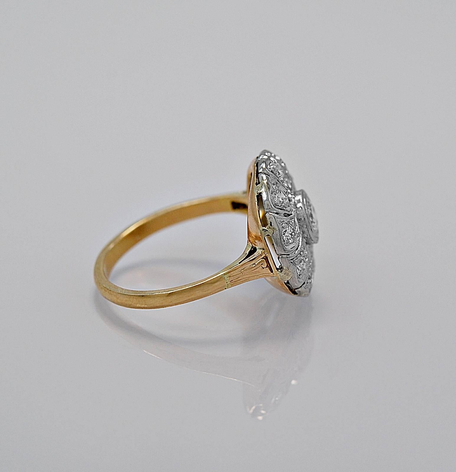 An artistically designed antique fashion ring featuring a .15ct. apx. center diamond with .20ct. apx. T.W. of diamond melee surrounding the edge of the round decorated disc head. It is beautifully crafted and finely finished. The two tone look with