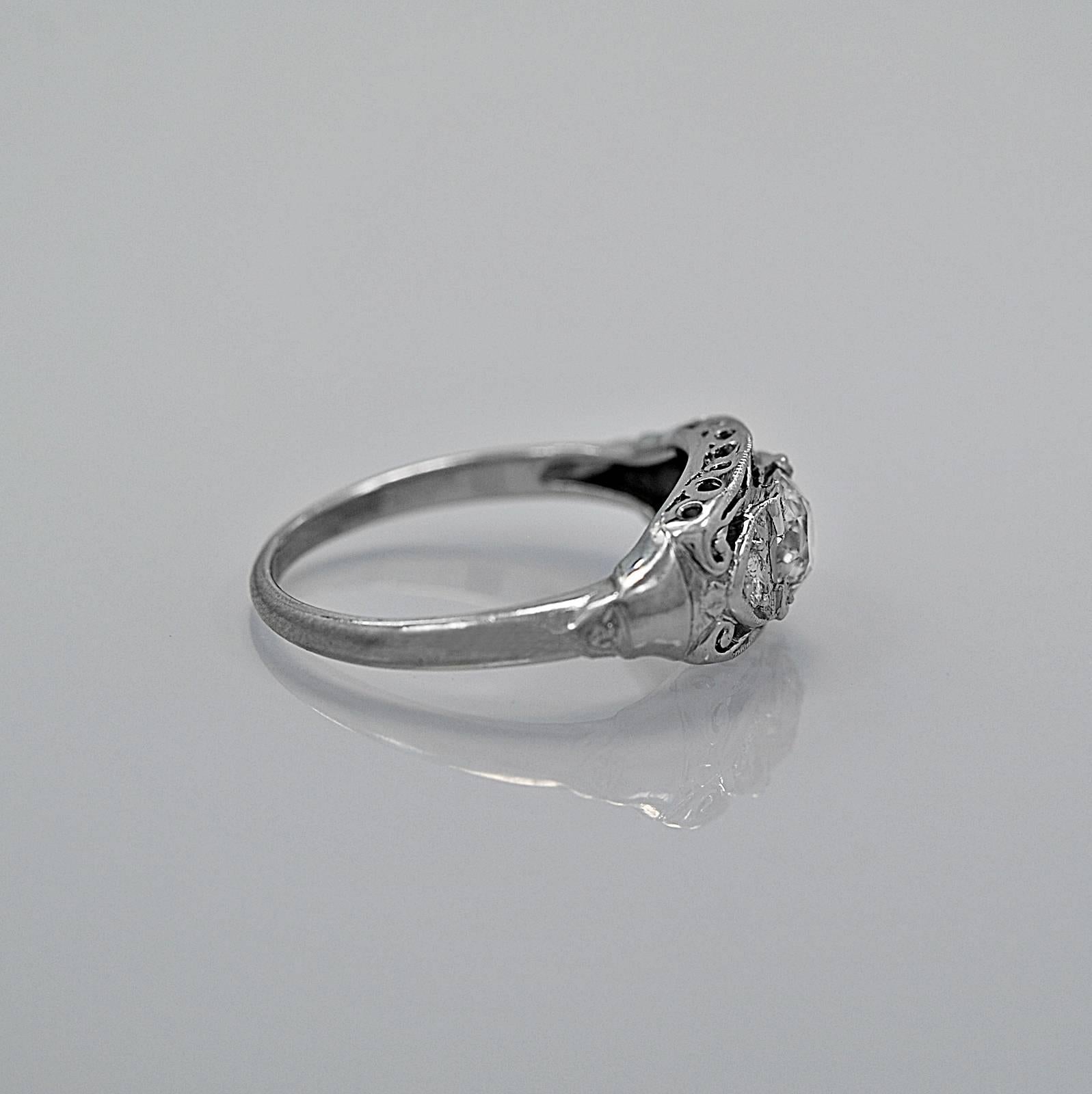 This gorgeous antique engagement ring crafted from diamond and platinum features a .72ct. apx. European cut diamond with J-K color and SI2 clarity. The .12ct. T.W. of transitional cut diamond melee are to the left and right of the center diamond. In