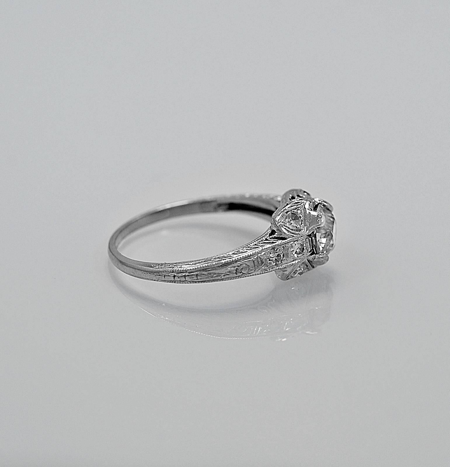 An original diamond antique engagement ring crafted in platinum and features a .75ct. apx. European cut center diamond with an accenting .15ct. apx. T.W. of diamond melee. This unique one-of-a-kind ring has beautiful piercing, milgrain and