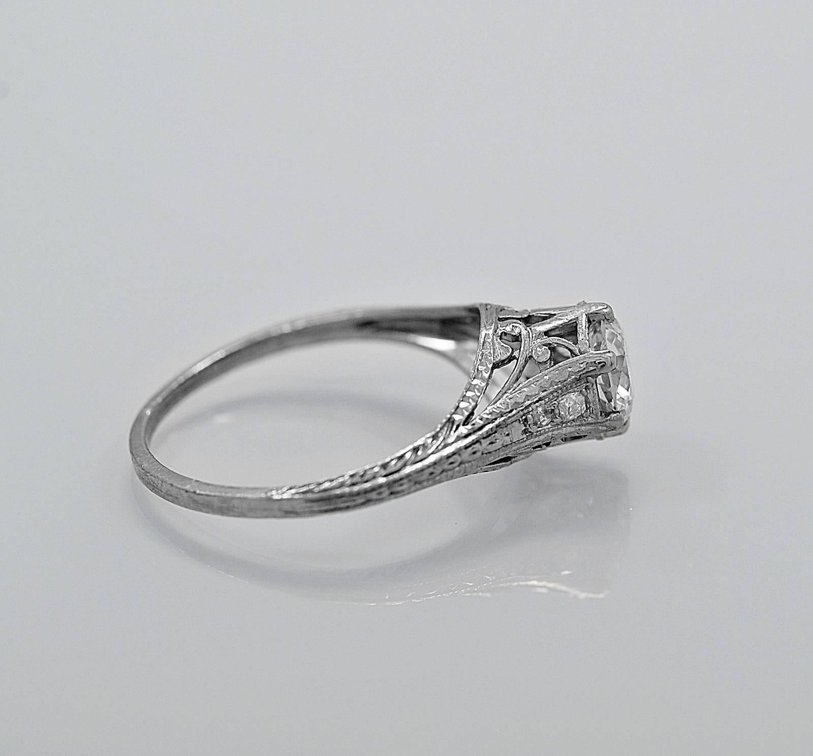 A delightful Art Deco platinum antique engagement ring featuring a .65ct. apx. European cut diamond with accenting .08ct. apx. T.W. diamond melee. The color is H with SI2 clarity. This ring is a stunning example of craftsmanship. The mounting