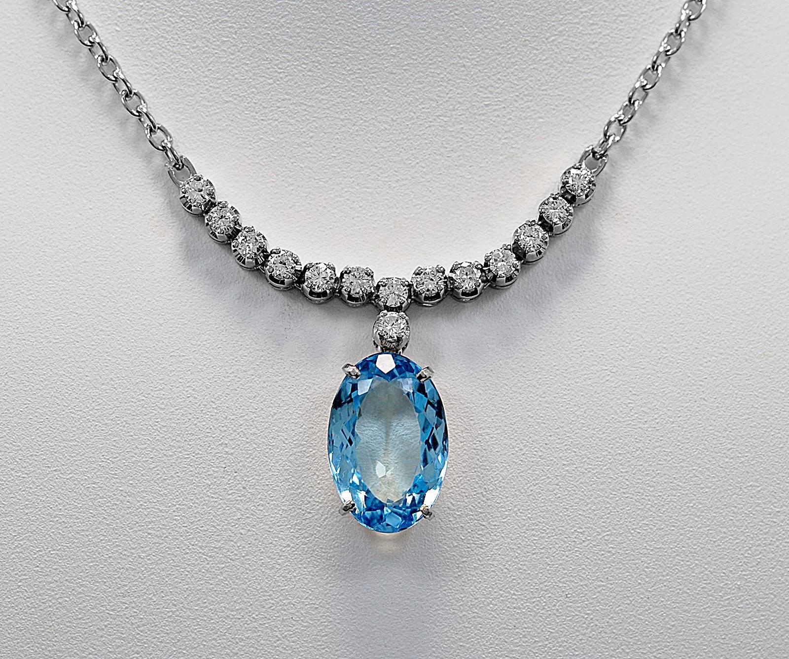 An elegant estate necklace crafted in 18K white gold with a 14K white gold chain. The oval aquamarine is a pretty blue eye clean stone which weighs 6.25ct. apx. The accenting diamonds which delicately decorate the base of the necklace above the