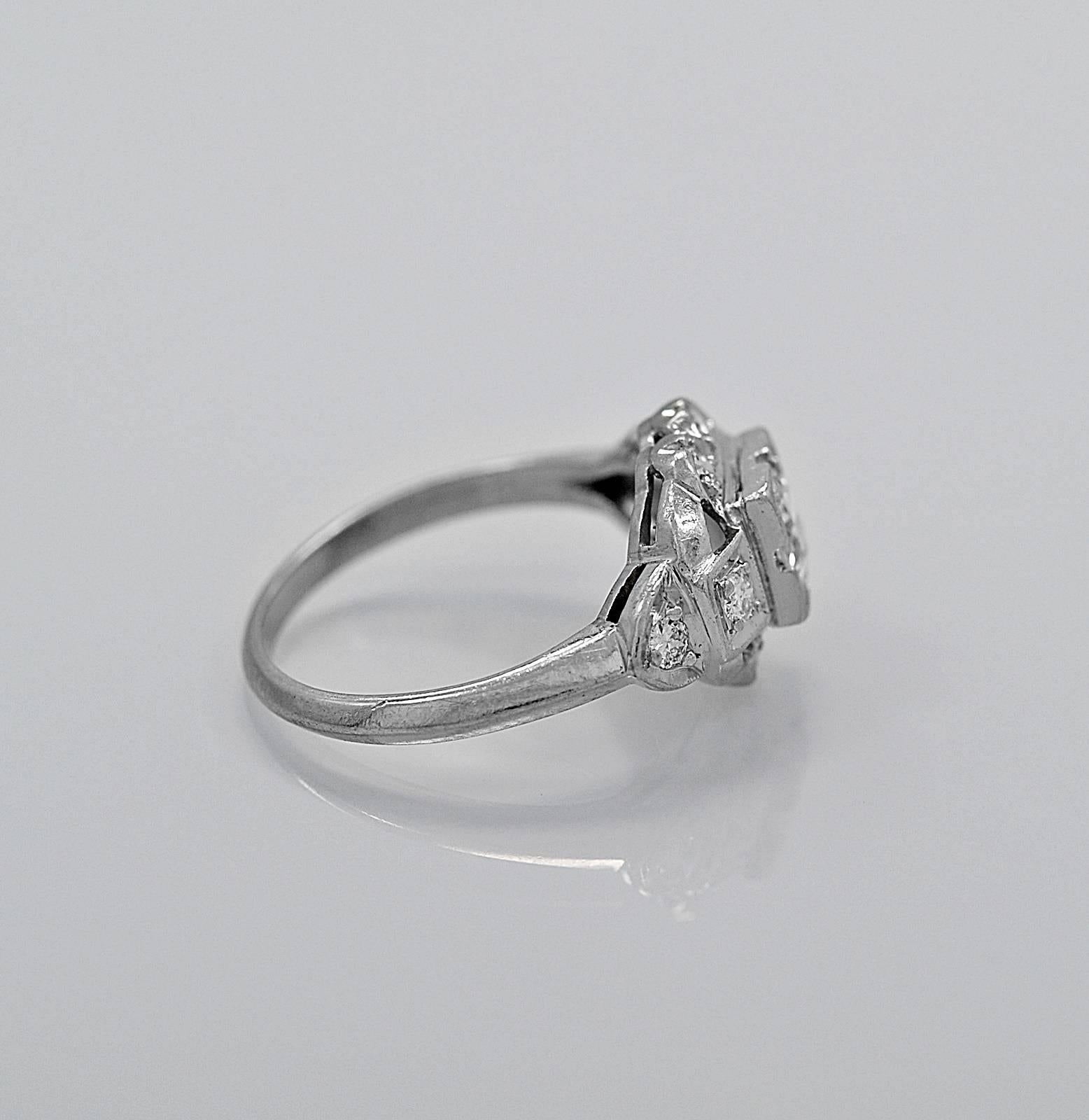 This Art Deco diamond antique engagement ring or fashion ring is crafted in platinum featuring a .38ct. apx. European cut diamond with I color and SI1 clarity. The accenting .20ct. T.W. apx. diamonds have scalloped edges on the north and south of