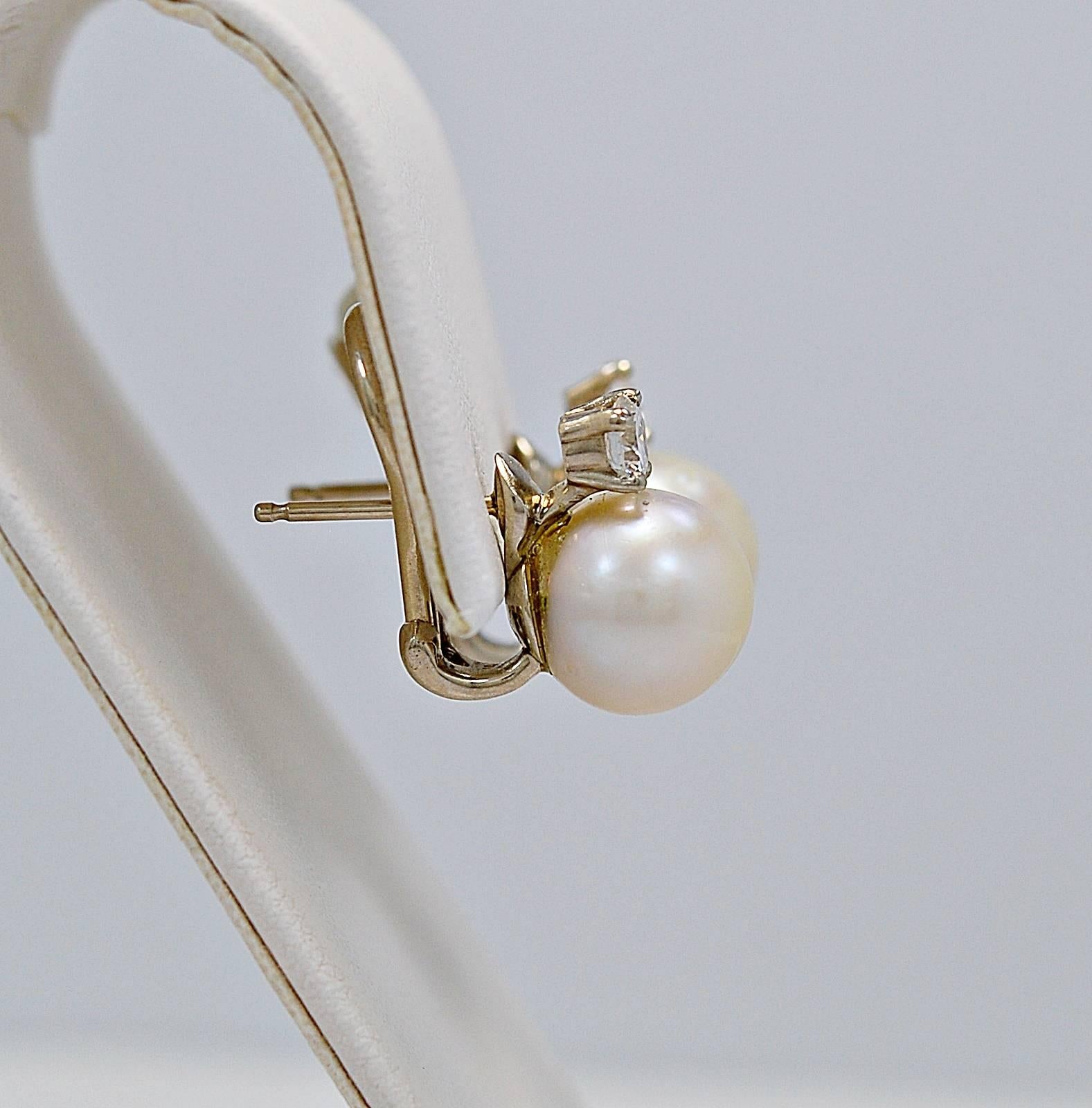 A gorgeous pair of estate earrings with omega backs and crafted in 18K yellow gold. The pearls are 10-10.2 mm and are accented with .66ct. apx. T.W. of round brilliant diamonds with SI1 clarity and G-H color. A classic and traditional look for