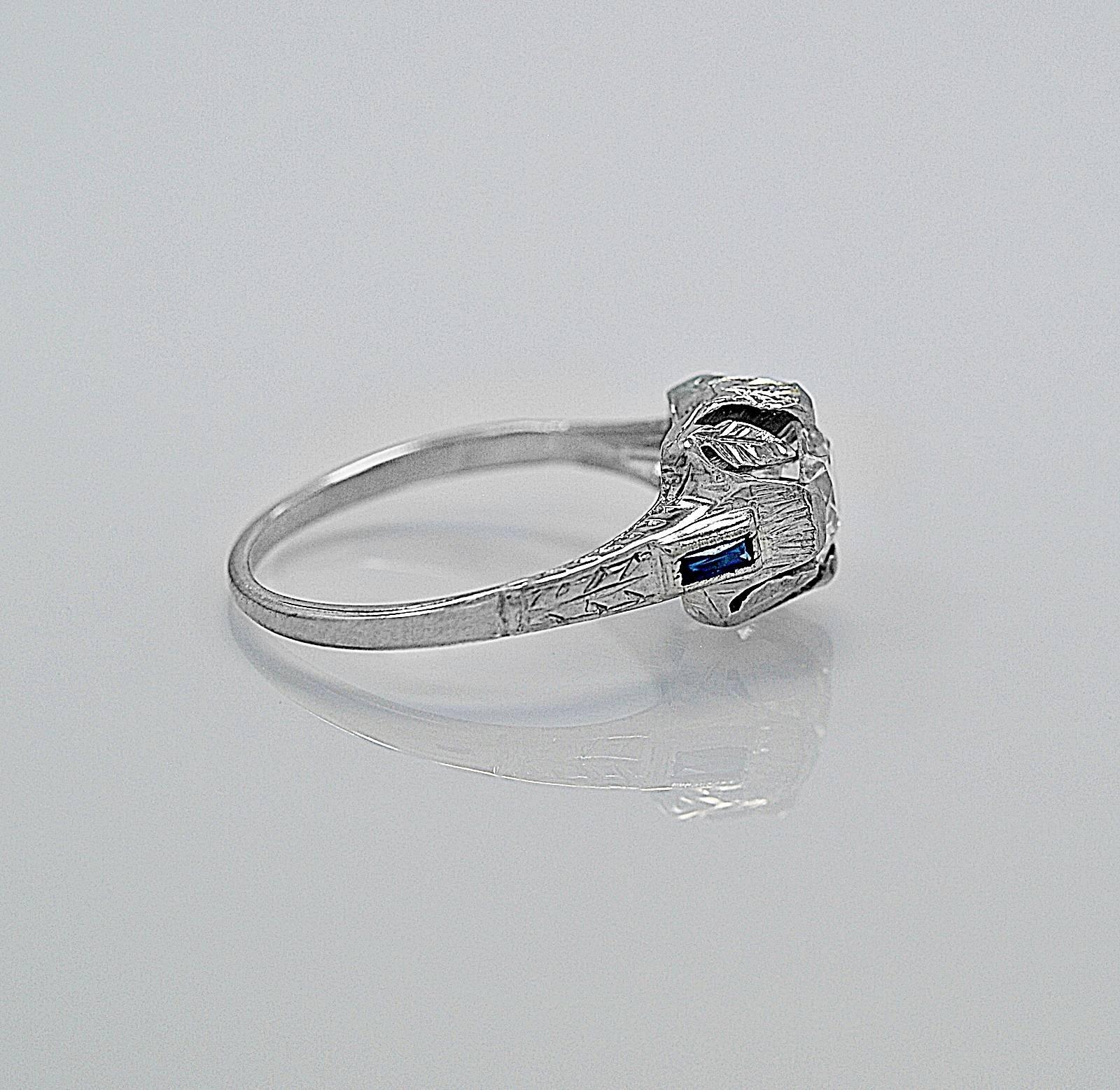 An artistically designed antique engagement ring crafted in 18K white gold and features a .89ct. apx. European cut center diamond with SI1 clarity and H-I color. The mounting is exceptional with piercings and engraving. Notice the leaves that are